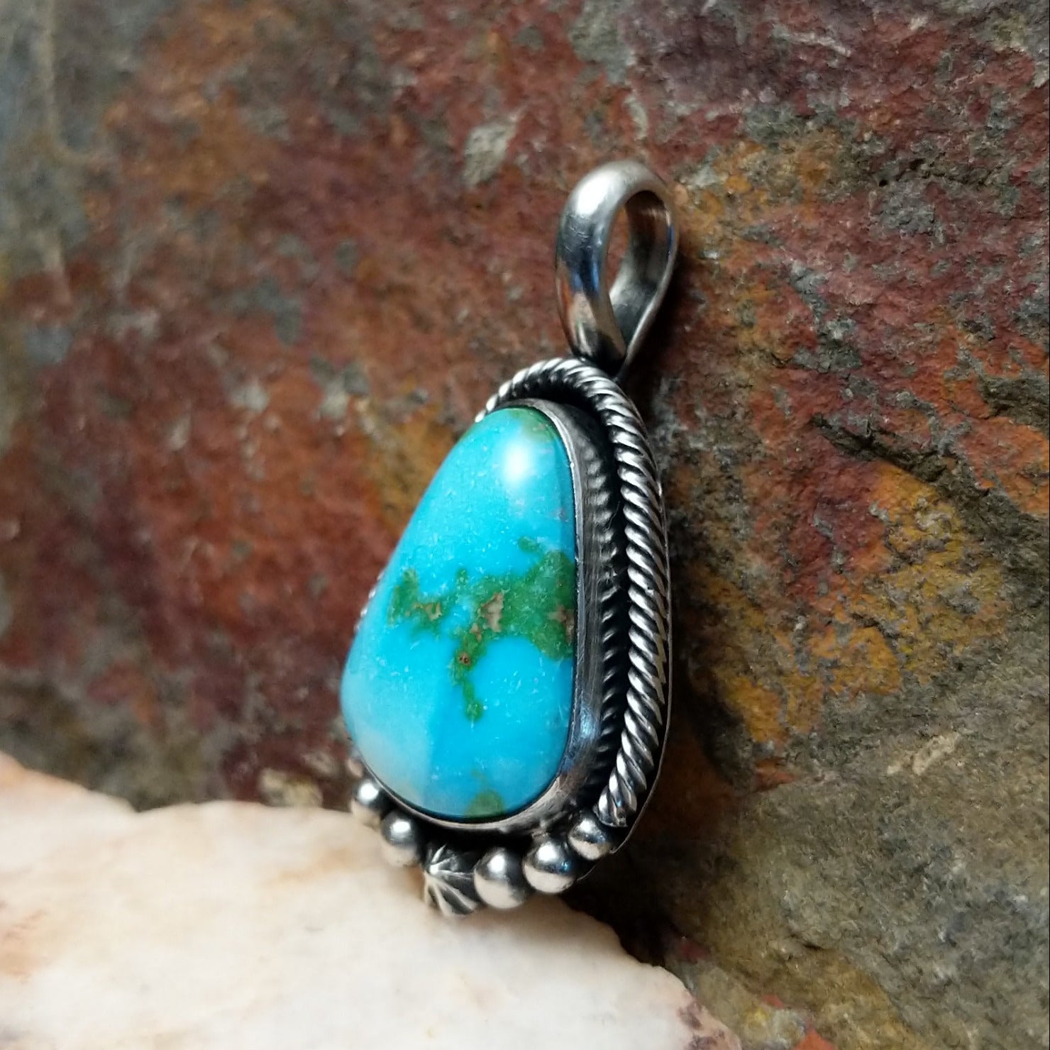 Sonoran Gold turquoise teardrop pendant by Navajo artist Bernyse Chavez, handcrafted in sterling silver, framed in rope setting - side view.