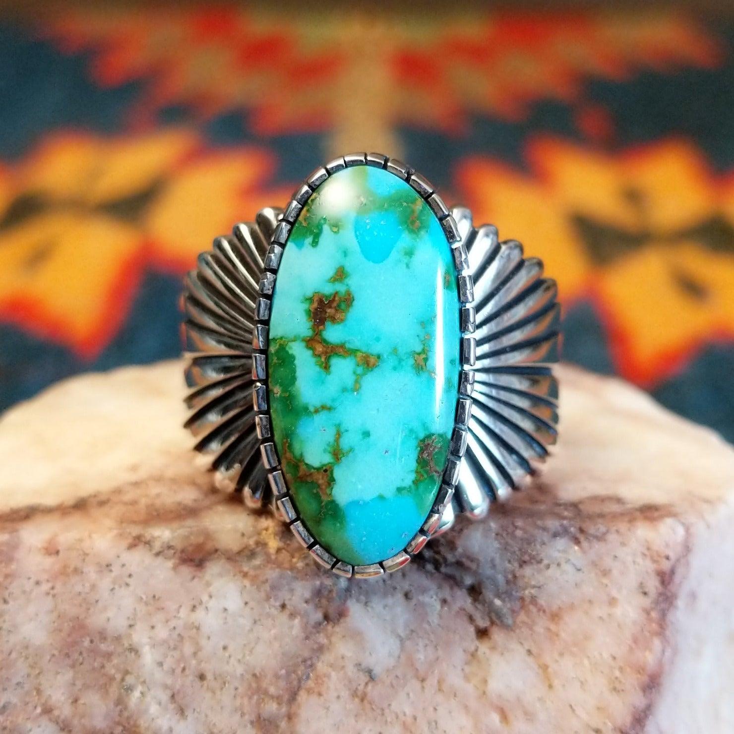 Sonoran Gold Turquoise stone in an ovoid shape, set in Sterling Silver. Made by Raymond Coriz, this ring is size 12; front view.