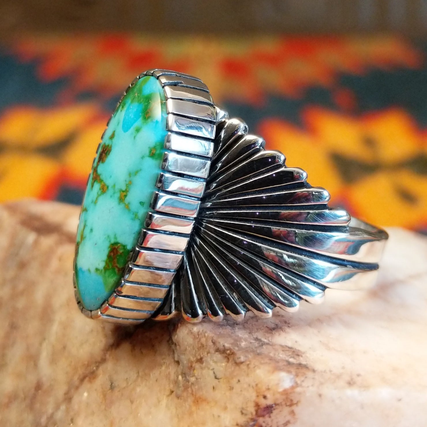 Sonoran Gold Turquoise stone in an ovoid shape, set in Sterling Silver. Made by Raymond Coriz, this ring is size 12, side view with band detail.