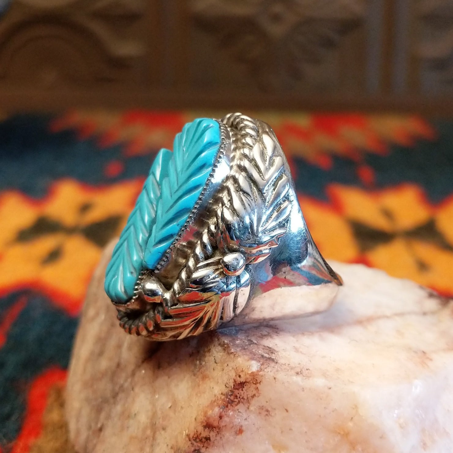 Size 9.75 Navajo ring, set in Sterling Silver, features a beautifully carved turquoise centerpiece set in sterling silver. Side view