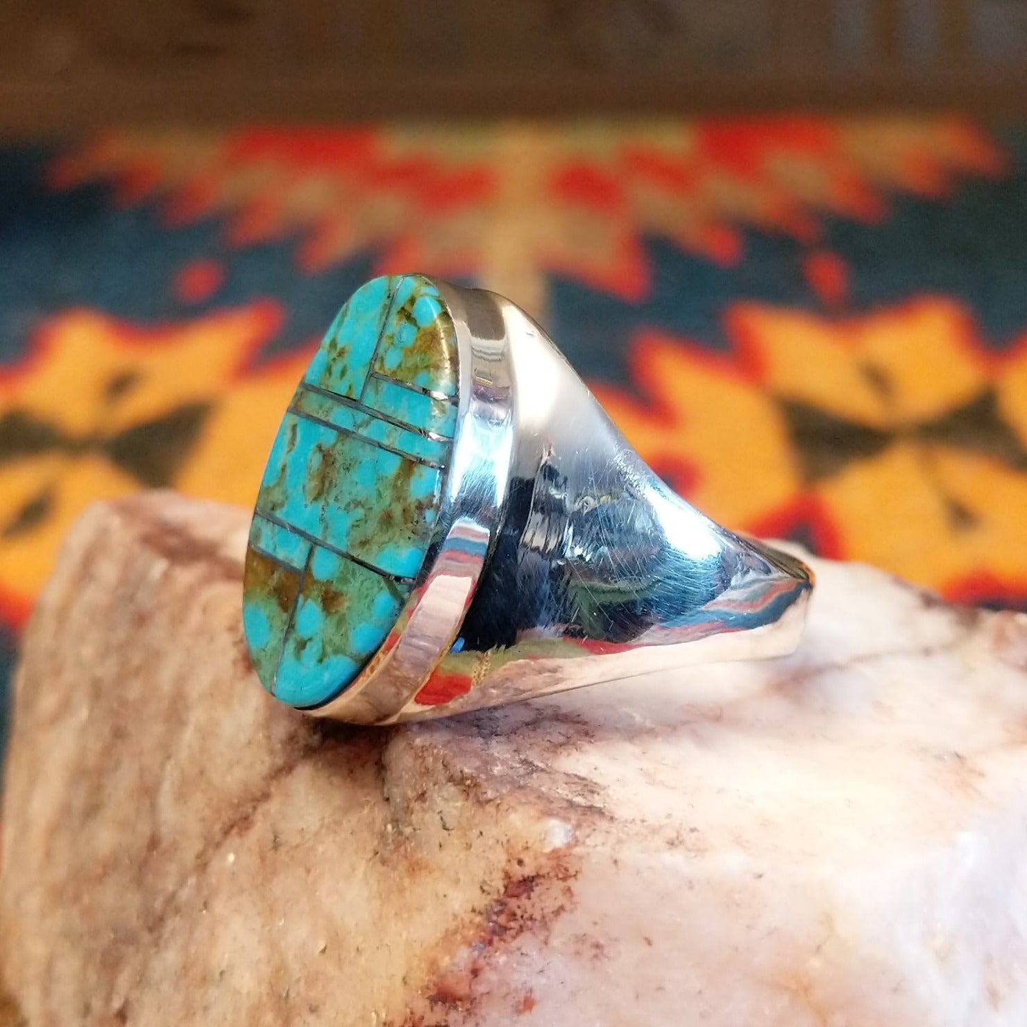 Size 11.5 ring by Wilbert Grey, features a bold oval inlay of vibrant turquoise set in sterling silver. Side view