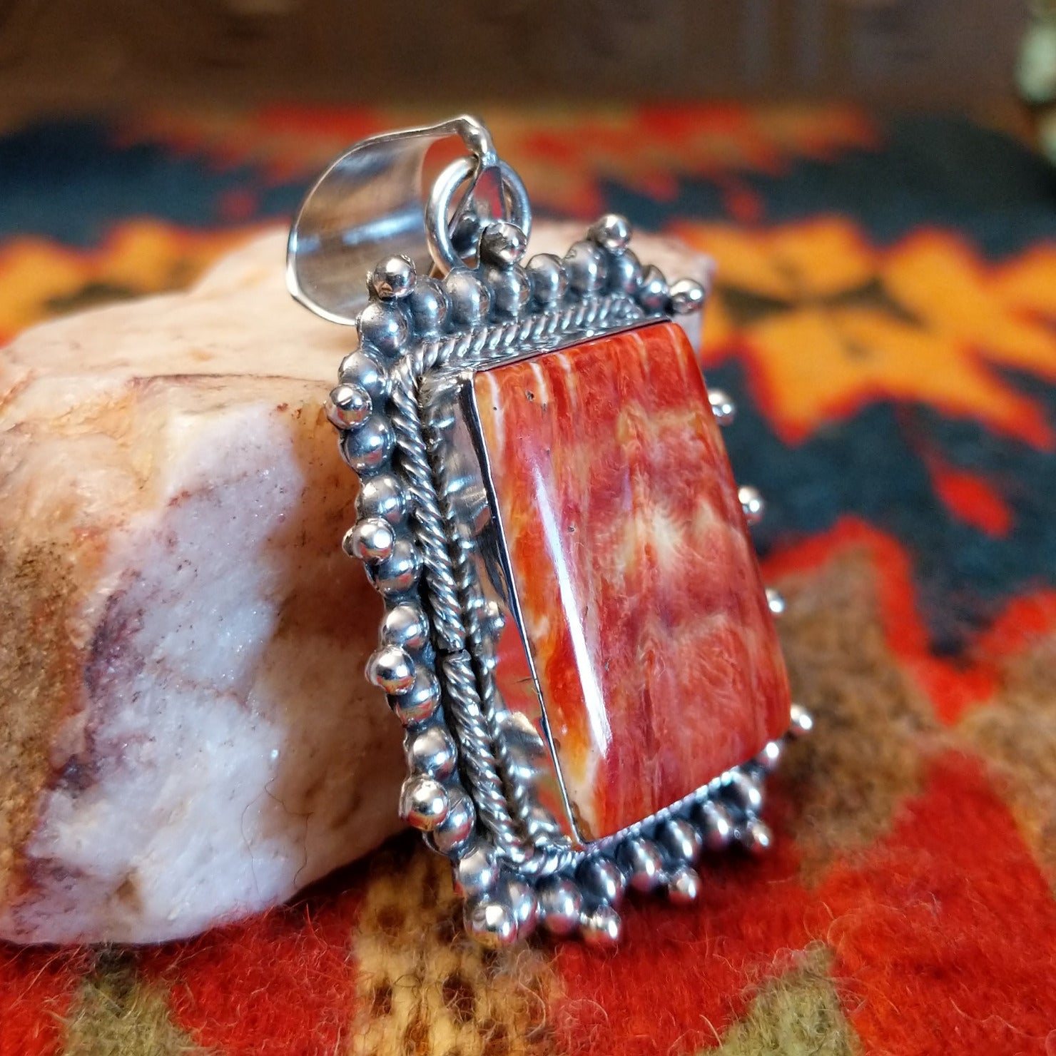 Handcrafted pendant by Verna Blackgoat features vibrant Red Spiny Oyster Shell. Side view
