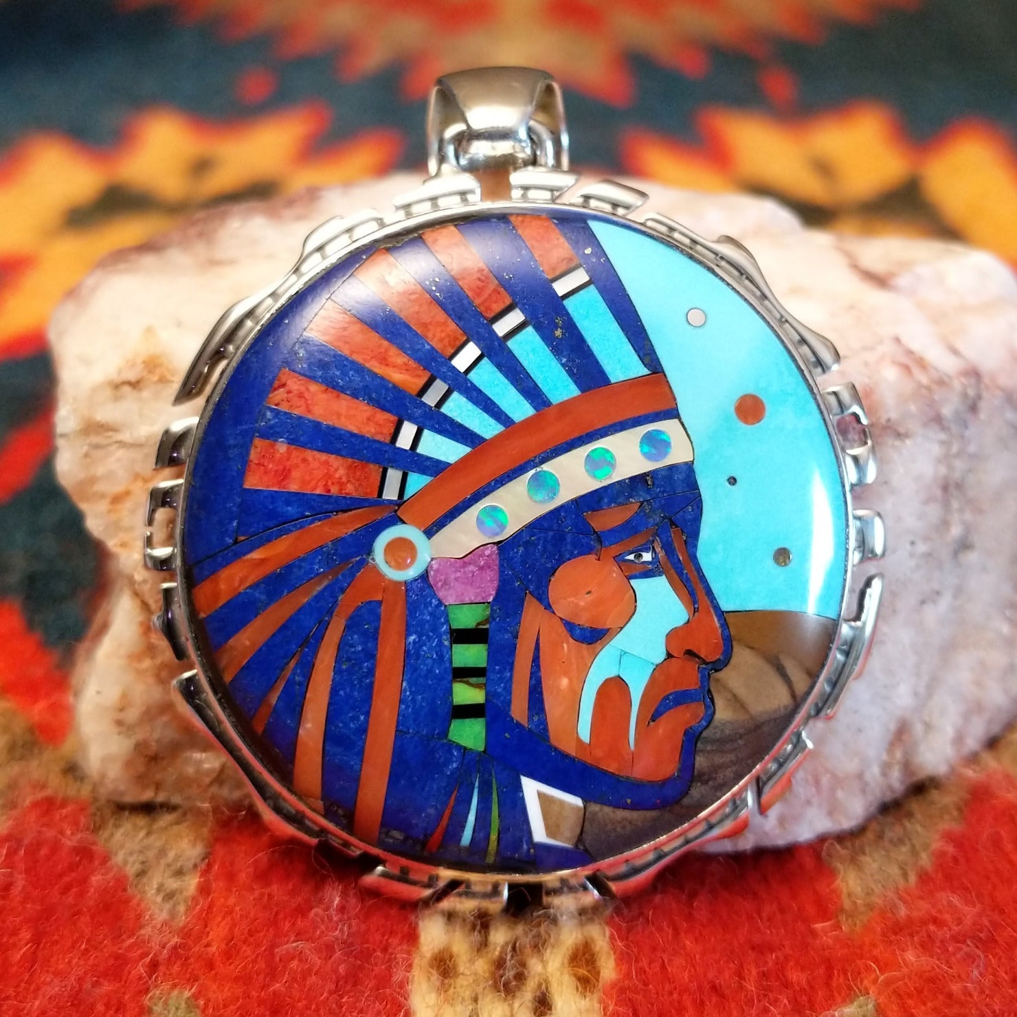Sterling Silver Navajo “Crying Chief” Pendant featuring turquoise, lapis, mother of pearl, blue manmade opal, magnesite, and gaspeite. Front view