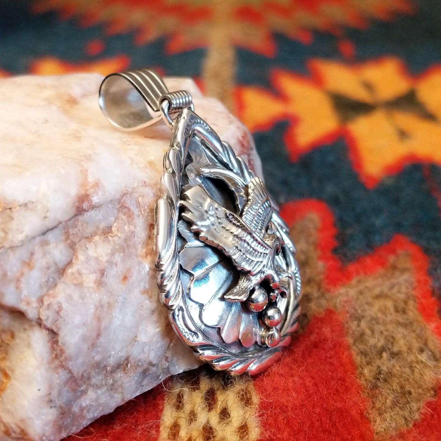 Navajo Eagle pendant handcrafted in sterling silver, featuring a soaring eagle set within a feathered and scrollwork frame. Side view