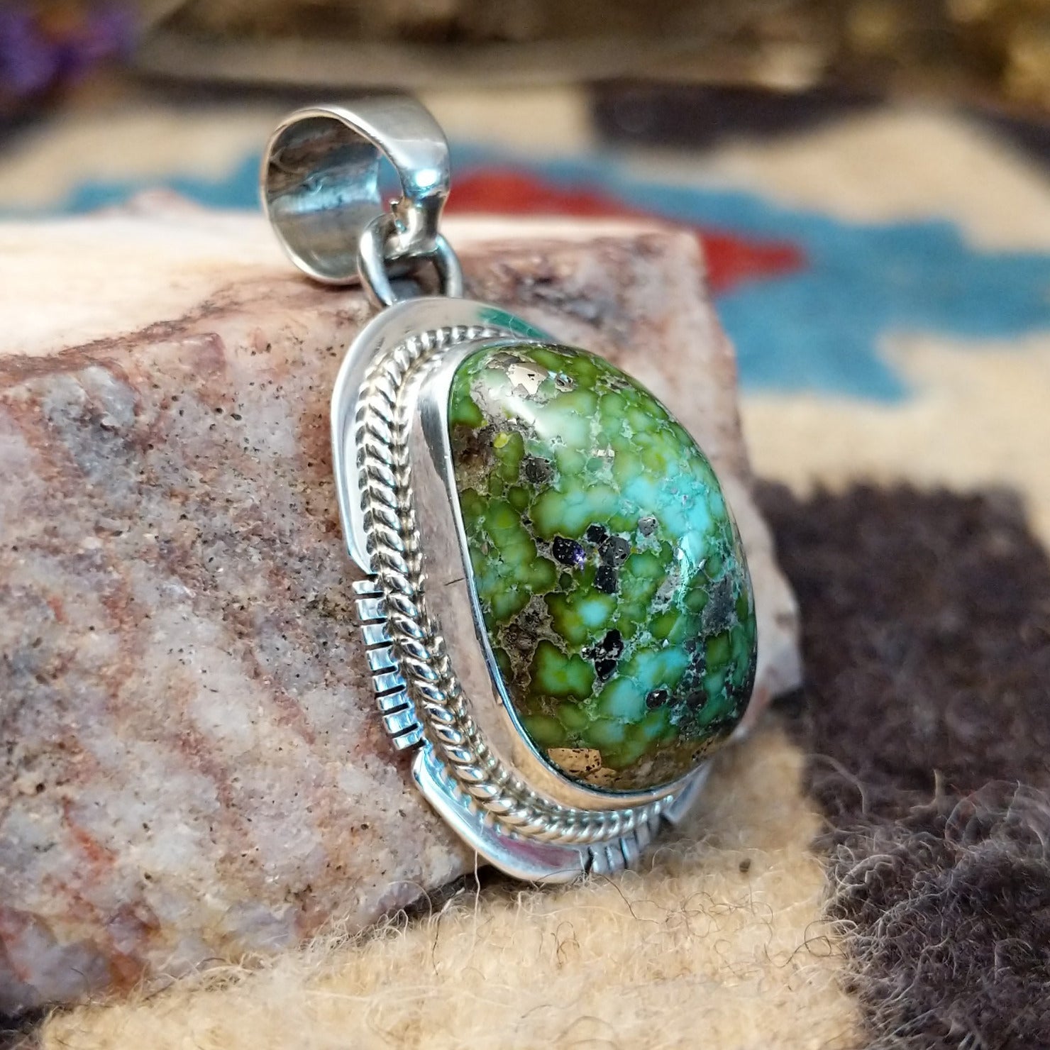Domed sterling silver pendant featuring a polished Sonoran Gold turquoise stone with blue-green coloring and natural golden matrix, handcrafted by Navajo artist Burt Francisco. Side View.