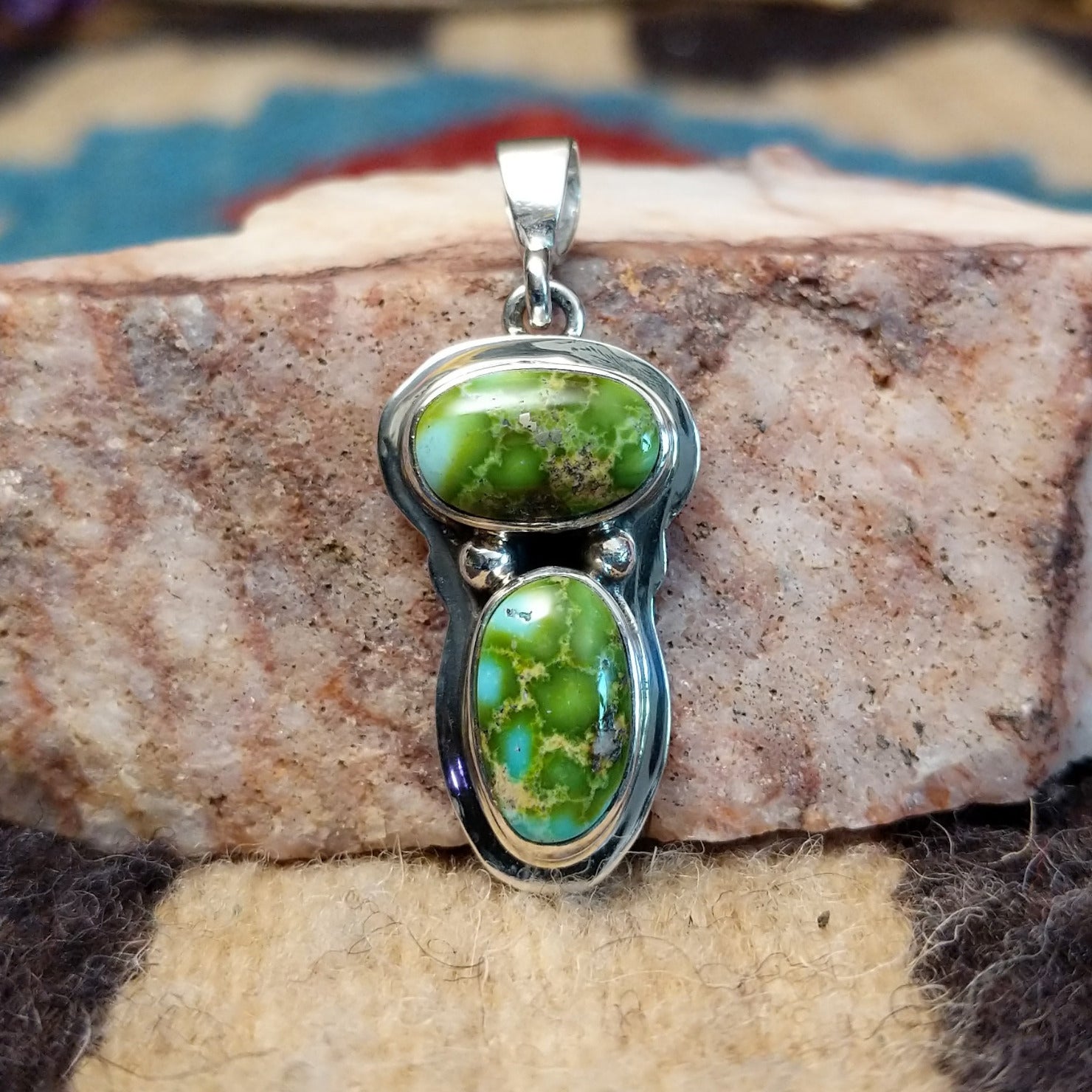 Sterling silver pendant with arranged Sonoran Gold turquoise stones displaying blue-green hues and natural golden matrix, handcrafted by artisan L.P. Front view.