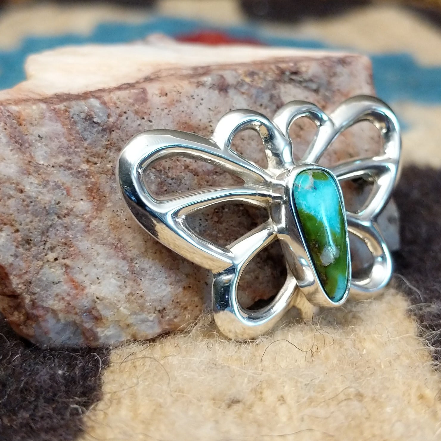 Sterling silver butterfly pin featuring Sonoran Gold turquoise stones with blue-green hues and natural golden matrix, handcrafted by Native American artist Francis Jones. Side view.