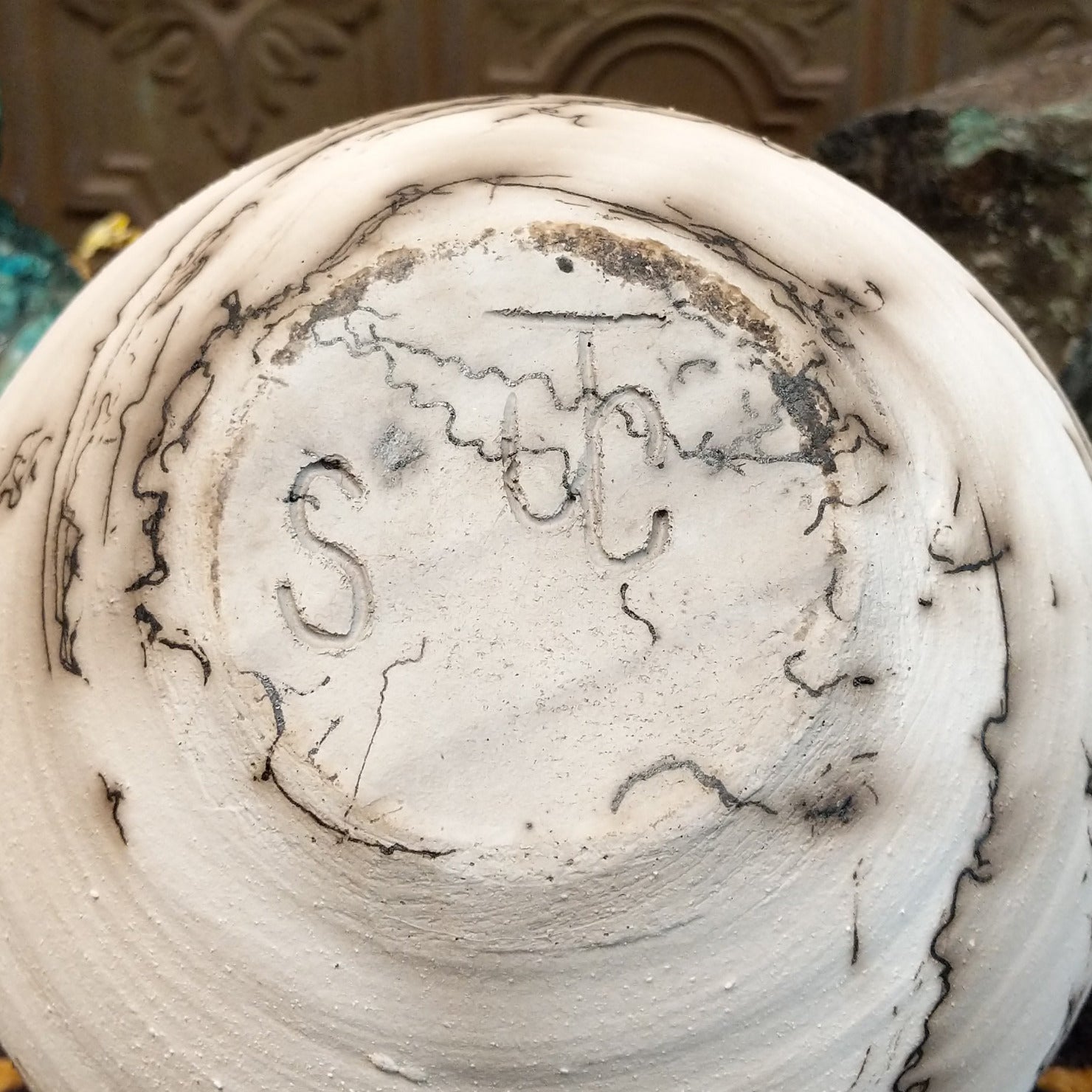 Medium globe-shaped white horsehair pottery vase by local artist Jim Calhoun featuring smoky organic patterns, a polished finish, and Southwestern handcrafted design. Underside view with artisan initials.