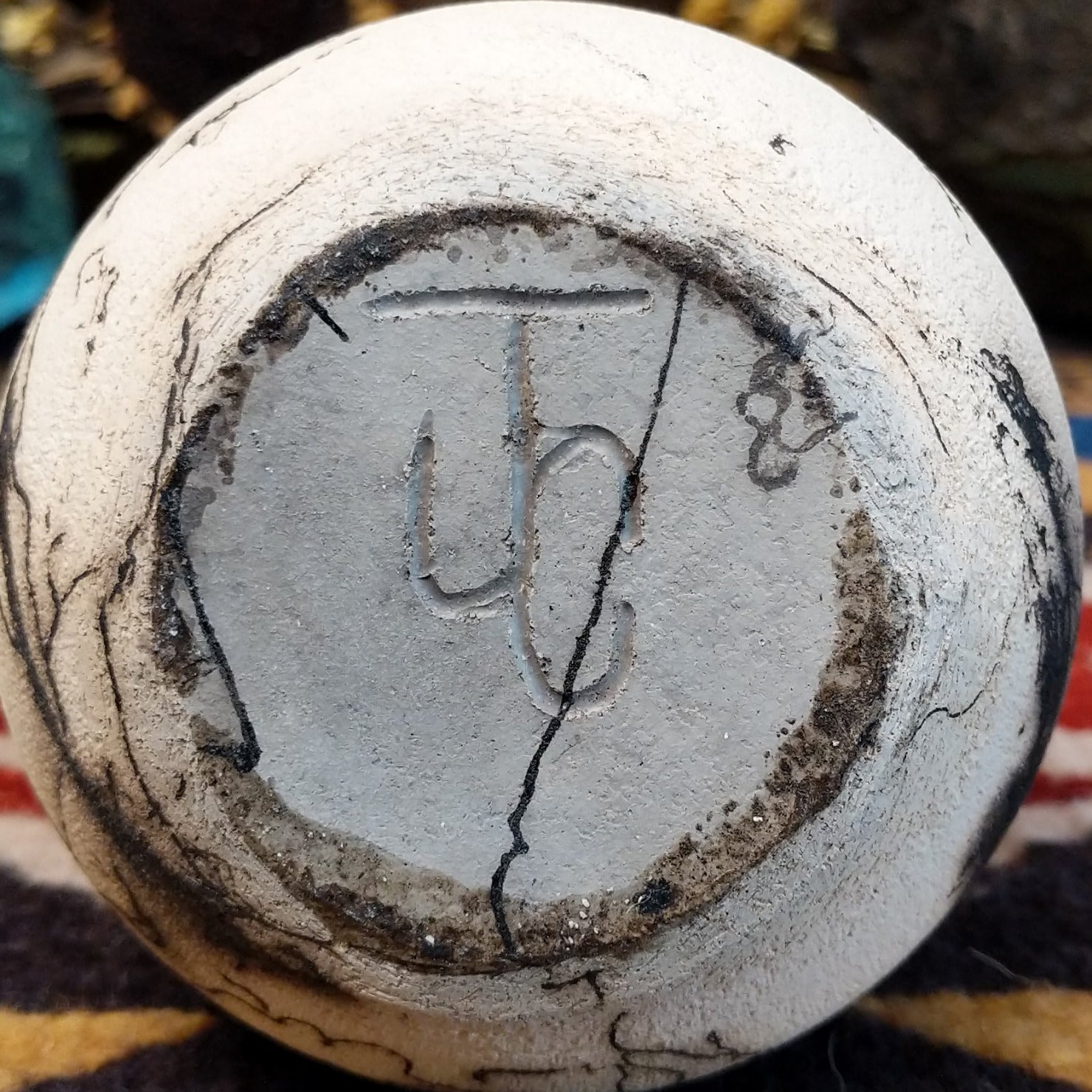 Small chiminea-style white horsehair pottery vase by local artisan Jim Calhoun with smoky natural patterns, polished finish, and handcrafted Southwestern design. Underside view of artisan initials.