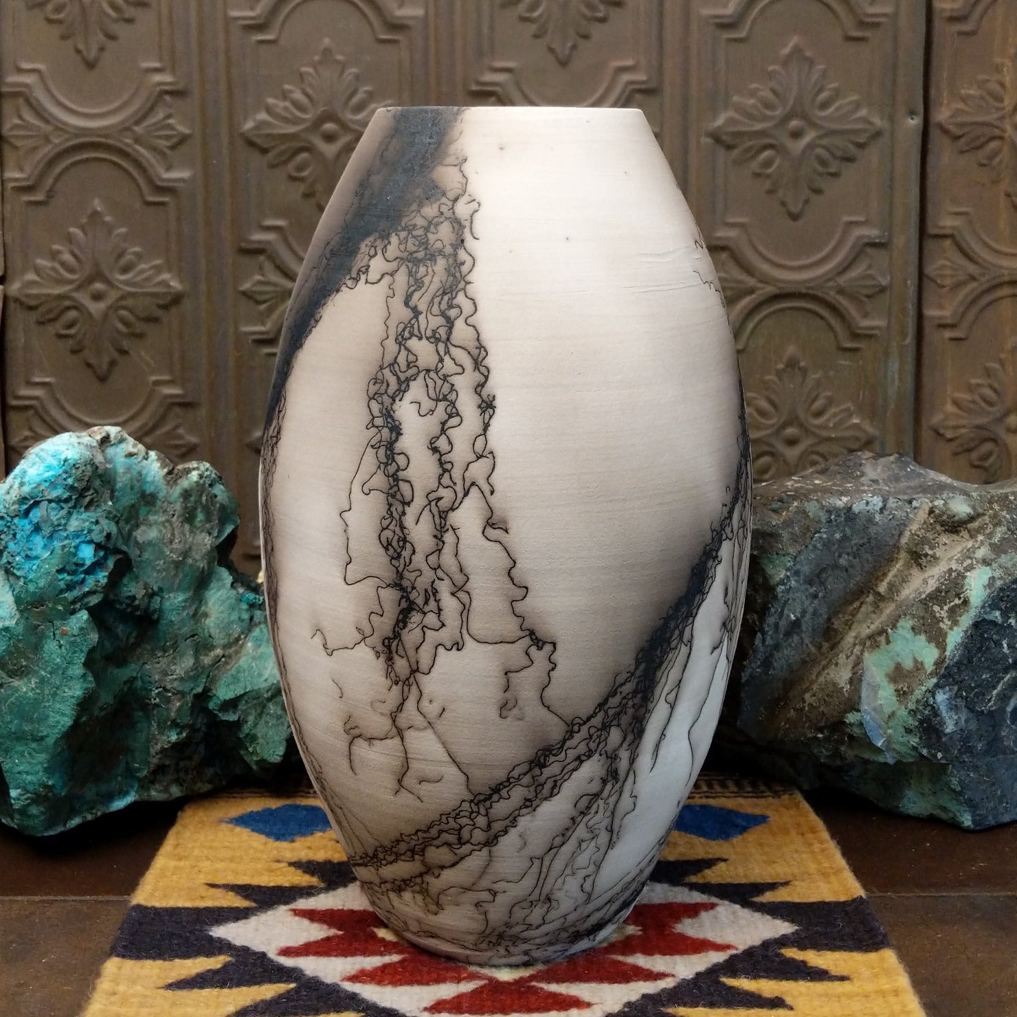 Large oval-shaped white horsehair pottery vase by local artisan Jim Calhoun featuring bold black smoky patterns, polished white finish, and handcrafted Southwestern design.