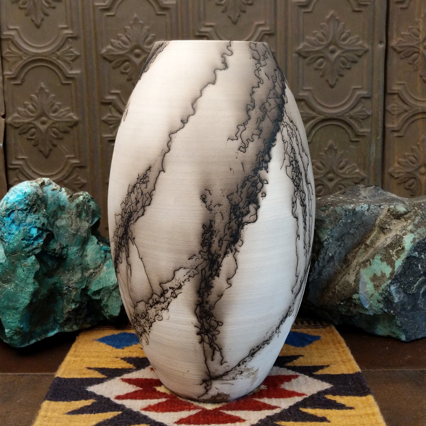 Large oval-shaped white horsehair pottery vase by local artisan Jim Calhoun featuring bold black smoky patterns, polished white finish, and handcrafted Southwestern design.