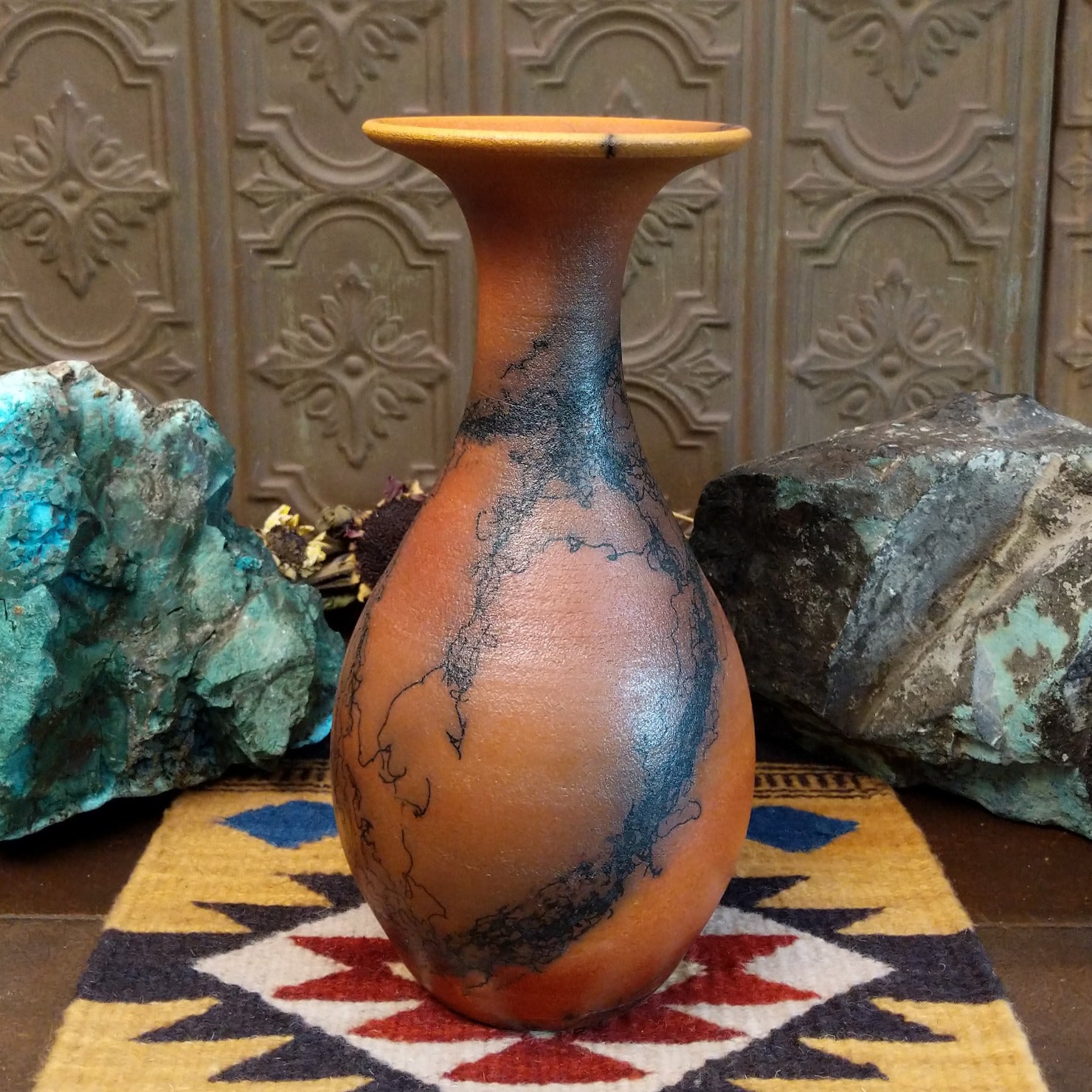 Flared terracotta horsehair vase handcrafted by local artisan Jim Calhoun, featuring a wide flared rim, earthy clay tones, and organic black horsehair fire patterns on the surface.
