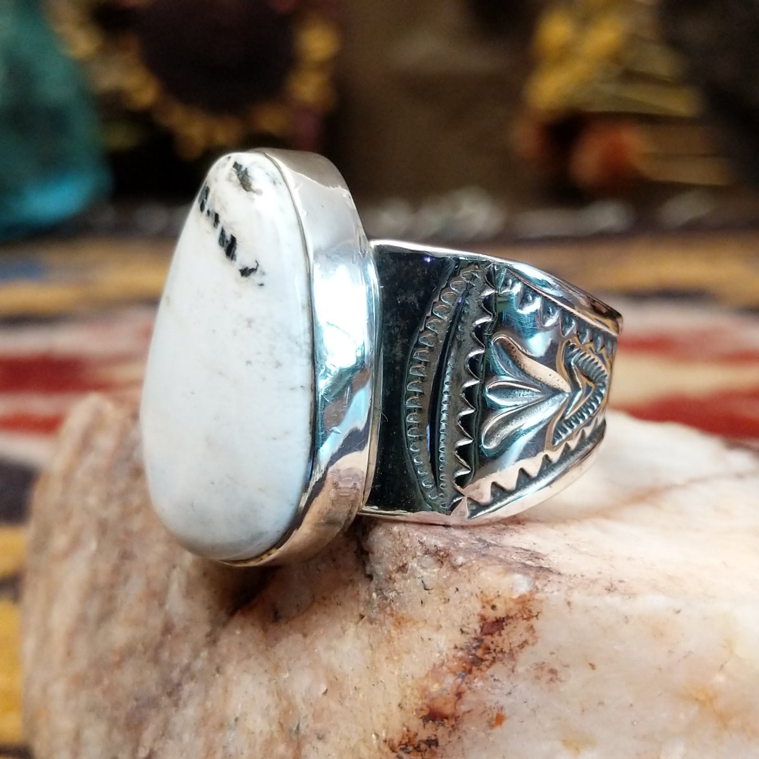 Sterling silver Navajo ovoid ring by L.P. featuring a polished White Buffalo stone set in a traditional handcrafted bezel. Side view.