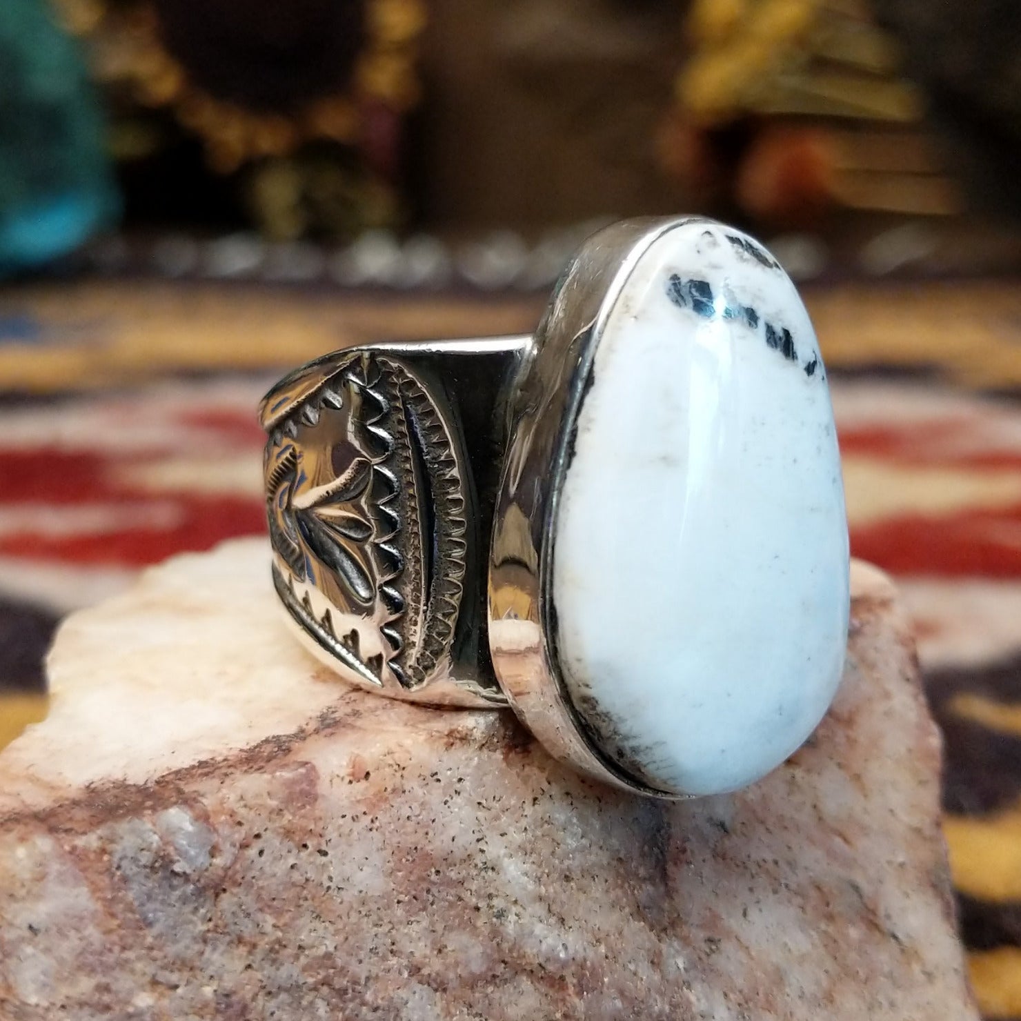 Sterling silver Navajo ovoid ring by L.P. featuring a polished White Buffalo stone set in a traditional handcrafted bezel. Side view.