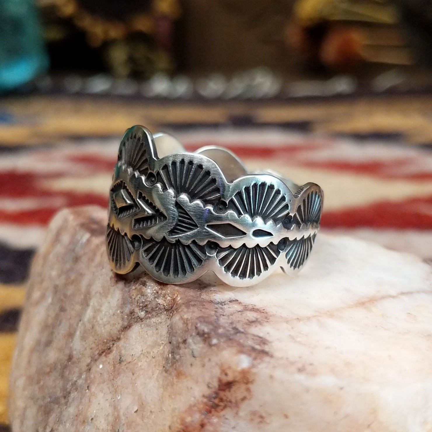 Handcrafted sterling silver scalloped ring by Elgin Tom featuring a polished finish and curved scalloped edges in a traditional Southwestern design. Side view.