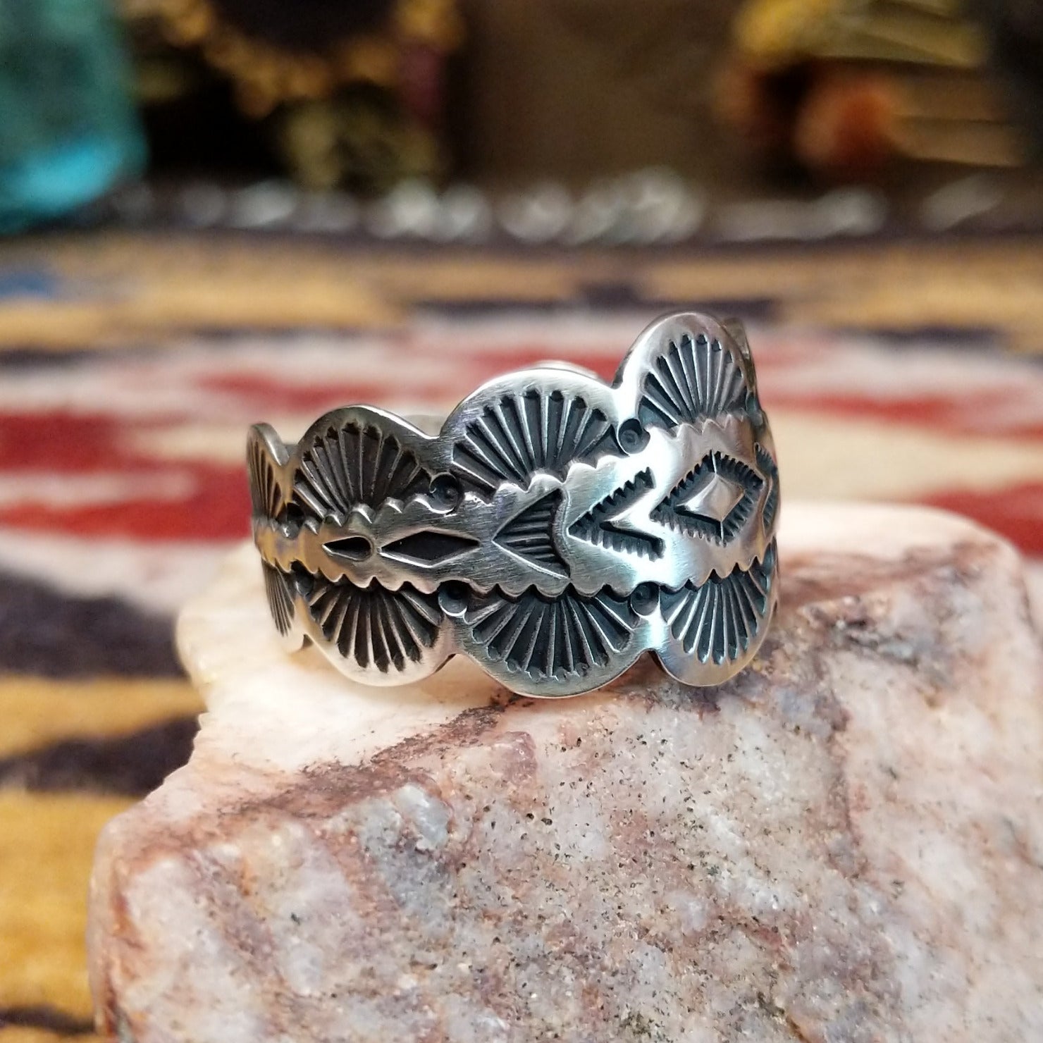 Handcrafted sterling silver scalloped ring by Elgin Tom featuring a polished finish and curved scalloped edges in a traditional Southwestern design. Side view.