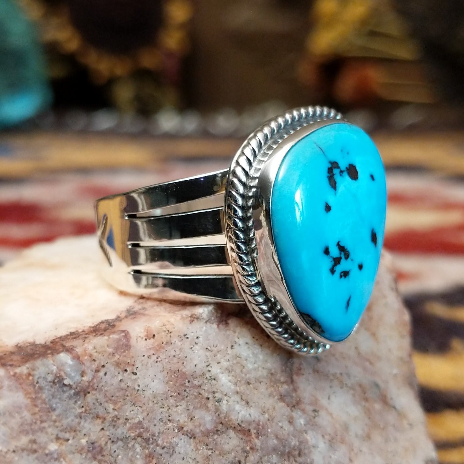 Handcrafted Navajo sterling silver ring by L.P. featuring a natural turquoise stone with traditional Southwestern silver detailing and a polished finish. Side view.