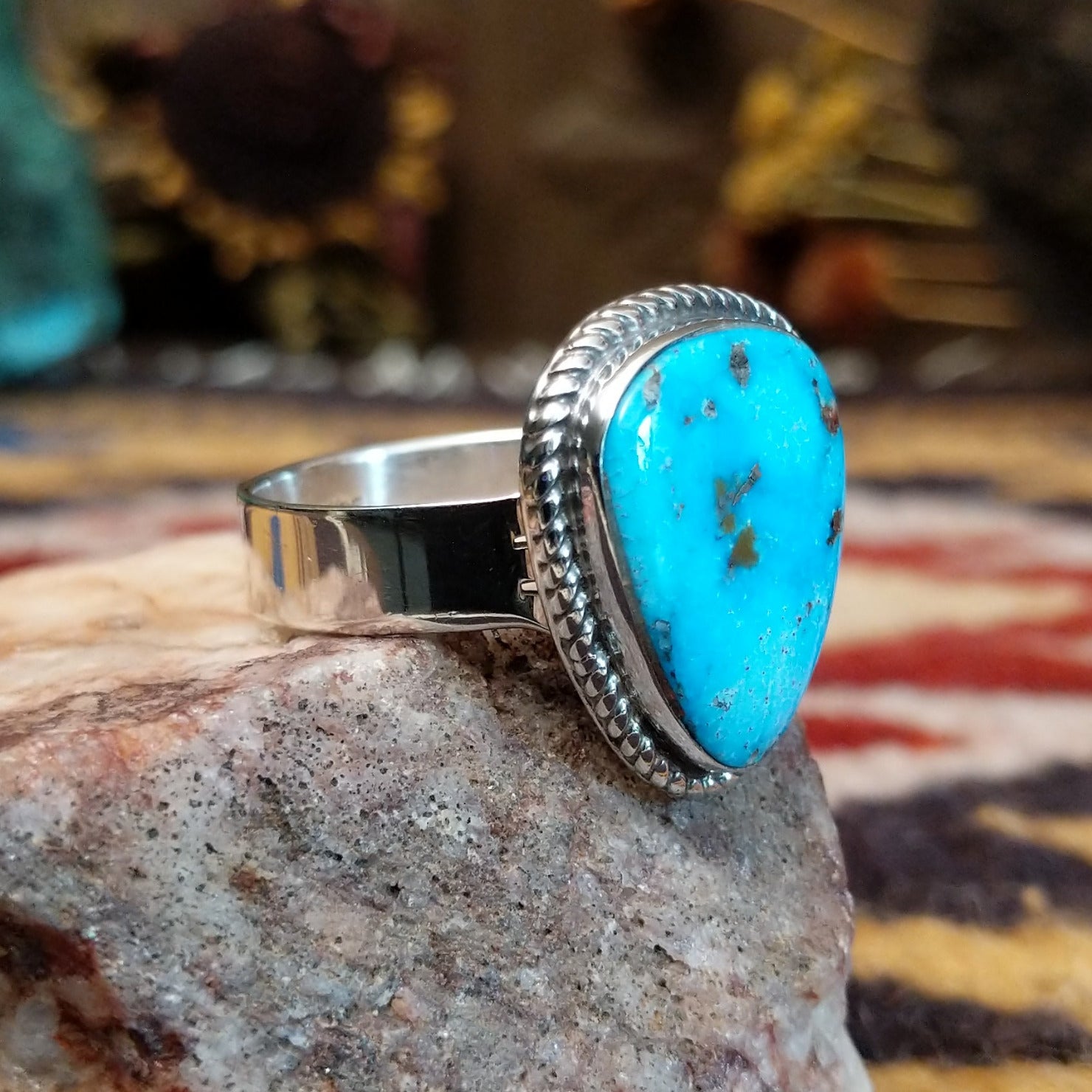 Handcrafted sterling silver ring by S.R. Chee featuring a triangular turquoise stone with traditional Southwestern Native American silver detailing. Side view.
