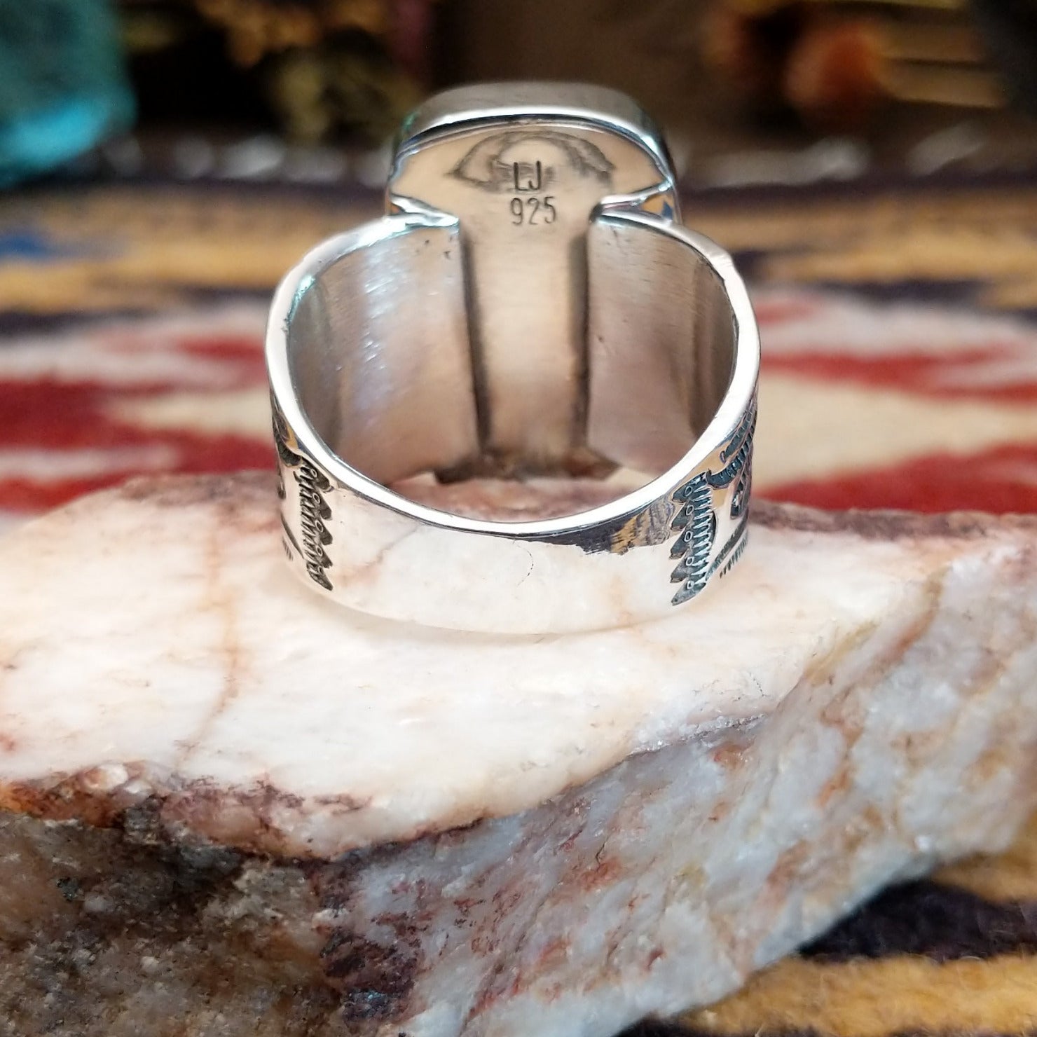 Handcrafted Navajo sterling silver ring by L.J. featuring a turquoise stone with traditional stamped silver detailing in a Southwestern design. Underside view.