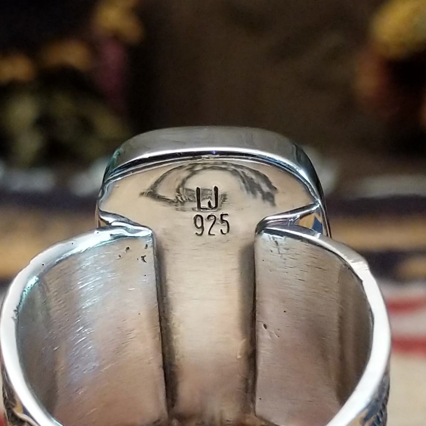 Handcrafted Navajo sterling silver ring by L.J. featuring a turquoise stone with traditional stamped silver detailing in a Southwestern design. Artisan and Sterling Silver stamp.