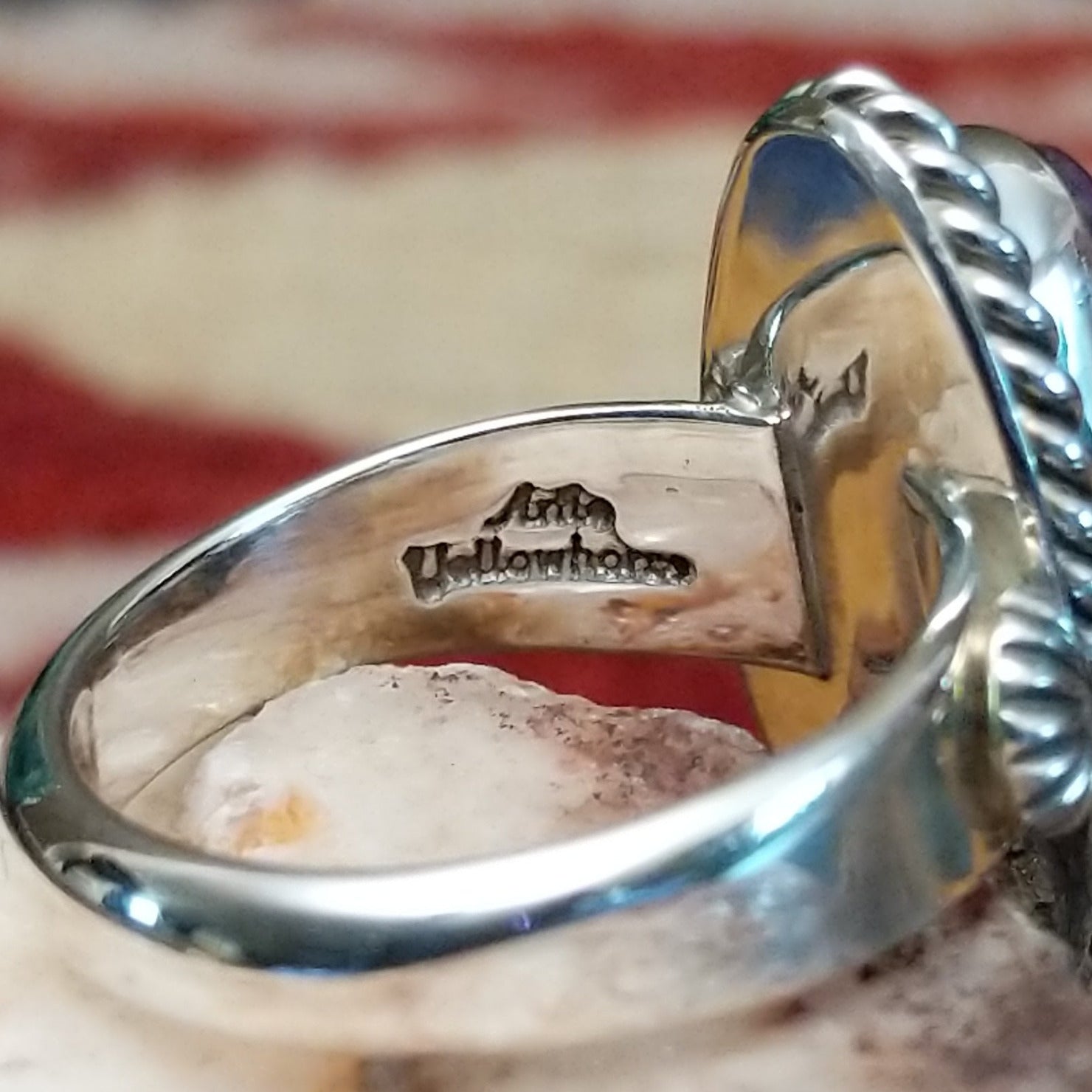 Handcrafted sterling silver ovoid ring by Artie Yellowhorse featuring a deep purple sugilite stone in a polished Southwestern Native American design. Artisan stamp on band.