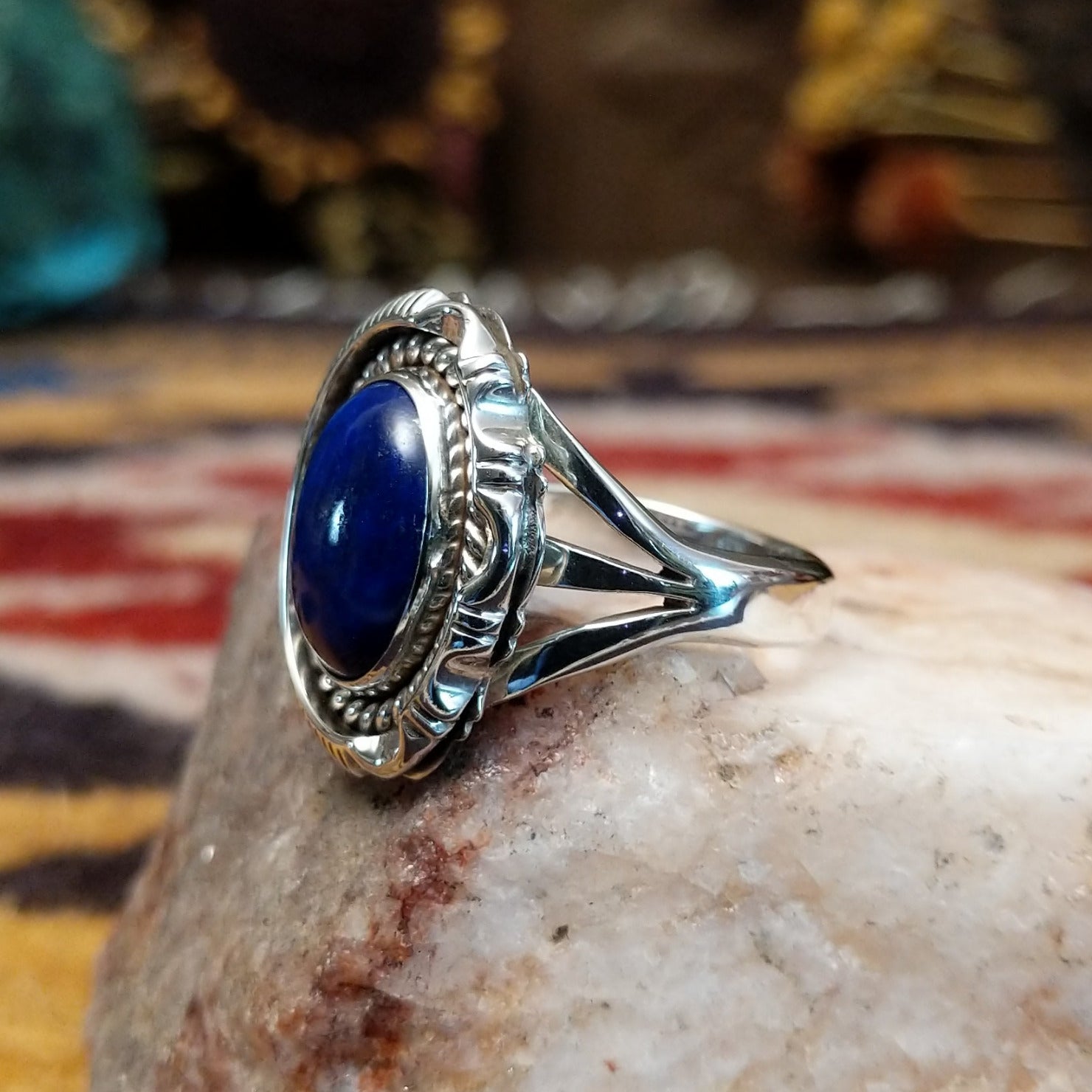 Handcrafted sterling silver oval ring by Artie Yellowhorse featuring a deep blue lapis stone in a polished Southwestern Native American design. Side view.