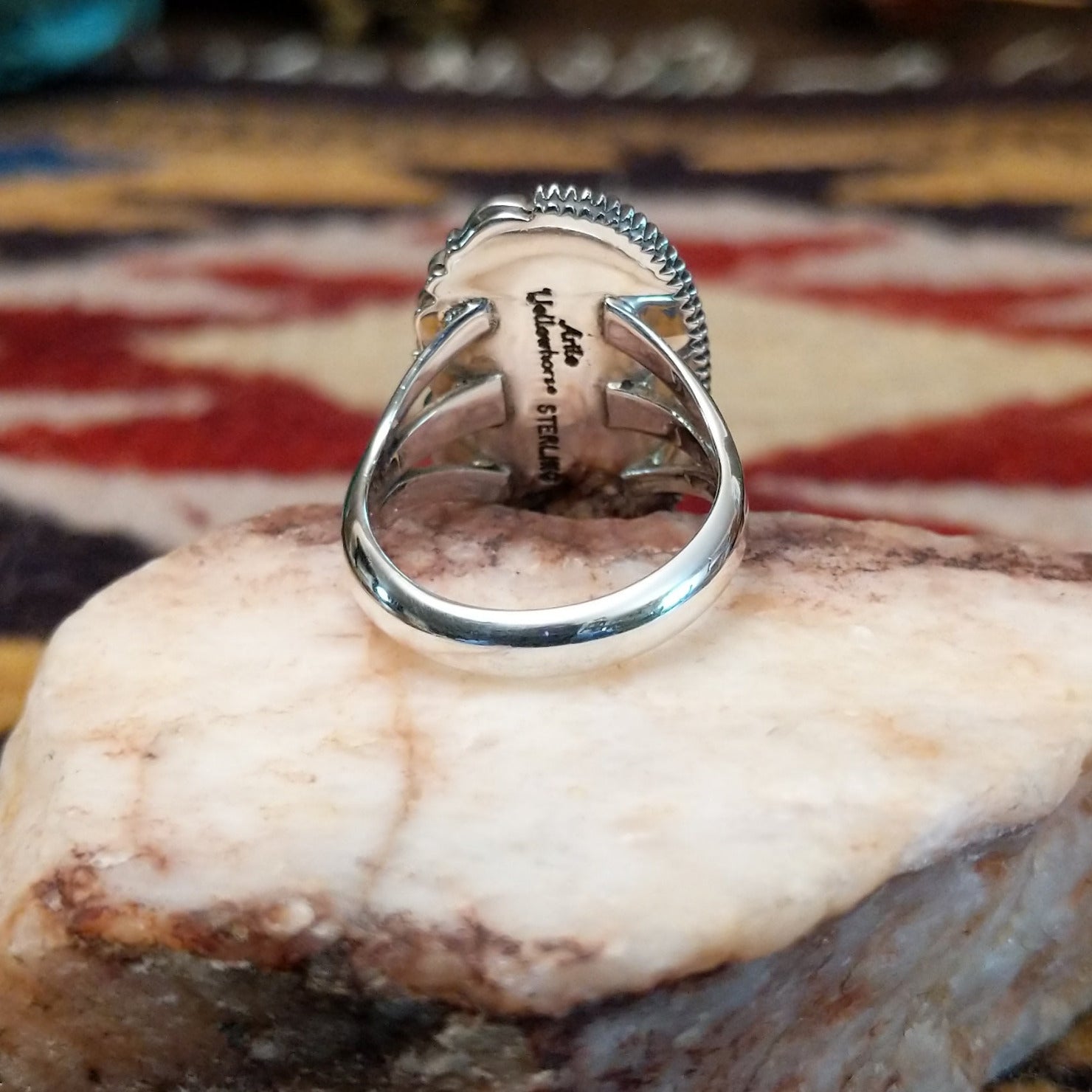 Handcrafted sterling silver ellipse ring by Artie Yellowhorse featuring a purple spiny oyster shell in a polished Southwestern Native American design. Underside view.