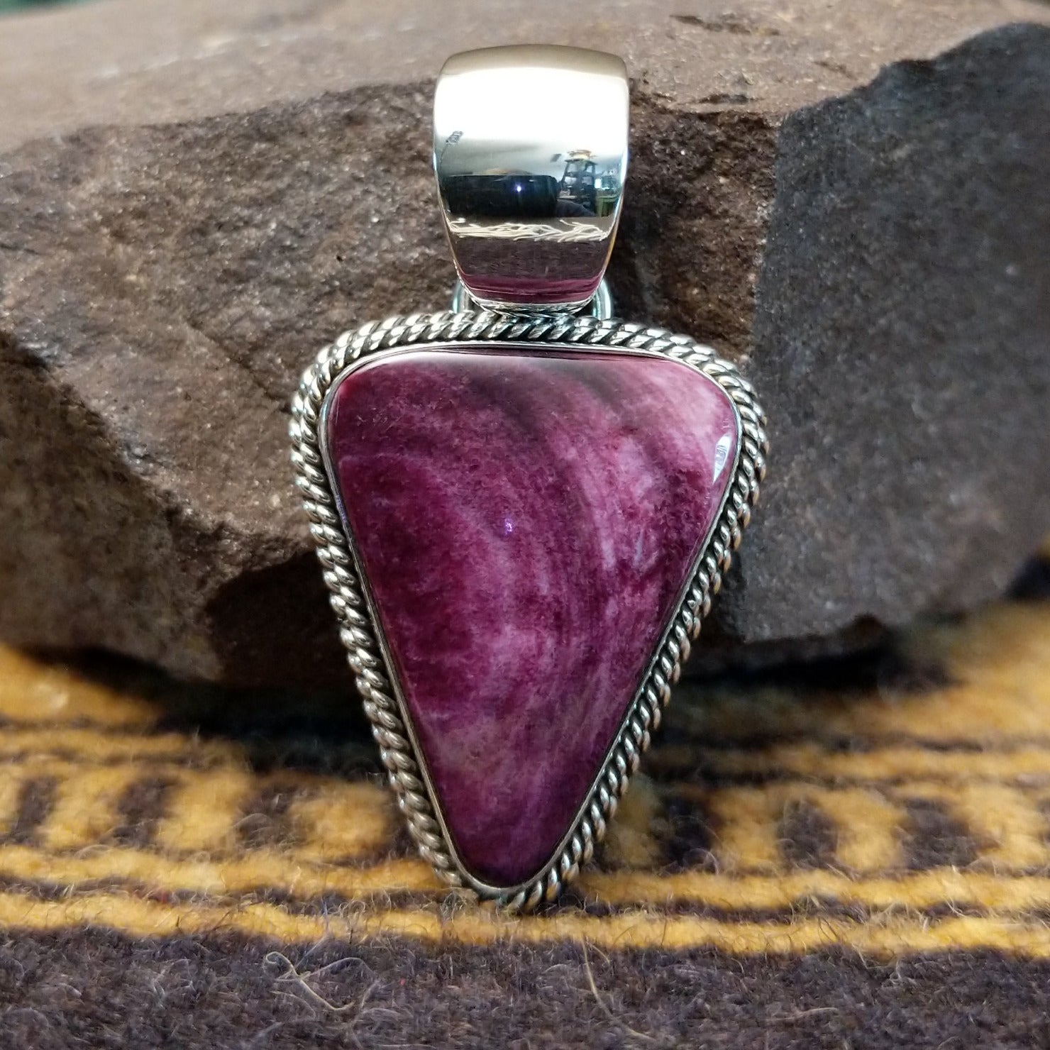 Handcrafted sterling silver pendant by Artie Yellowhorse featuring a purple spiny oyster shell in a triangular Southwestern Native American design.