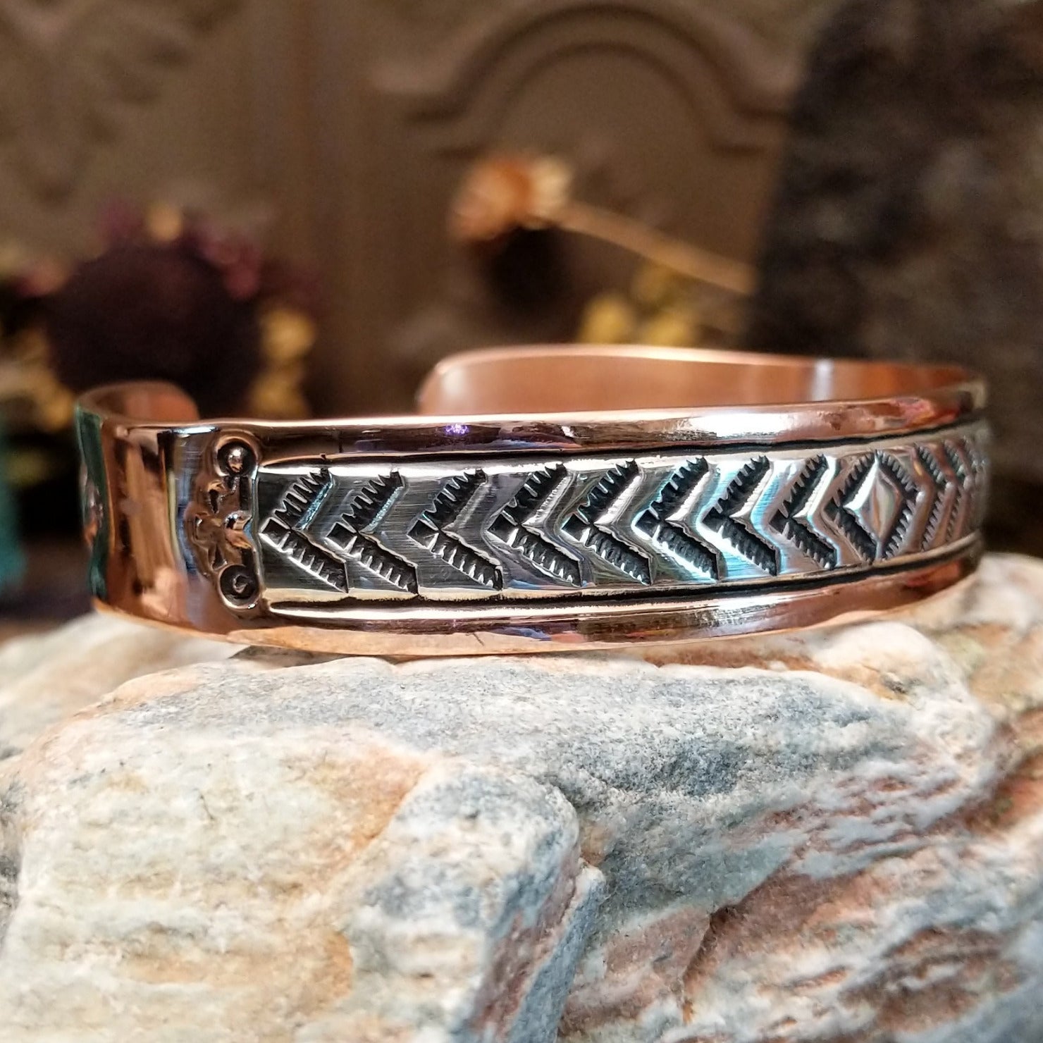 Handcrafted copper and sterling silver cuff bracelet by Robert Little featuring chevron-stamped detailing in a traditional Southwestern Native American design. Side view.