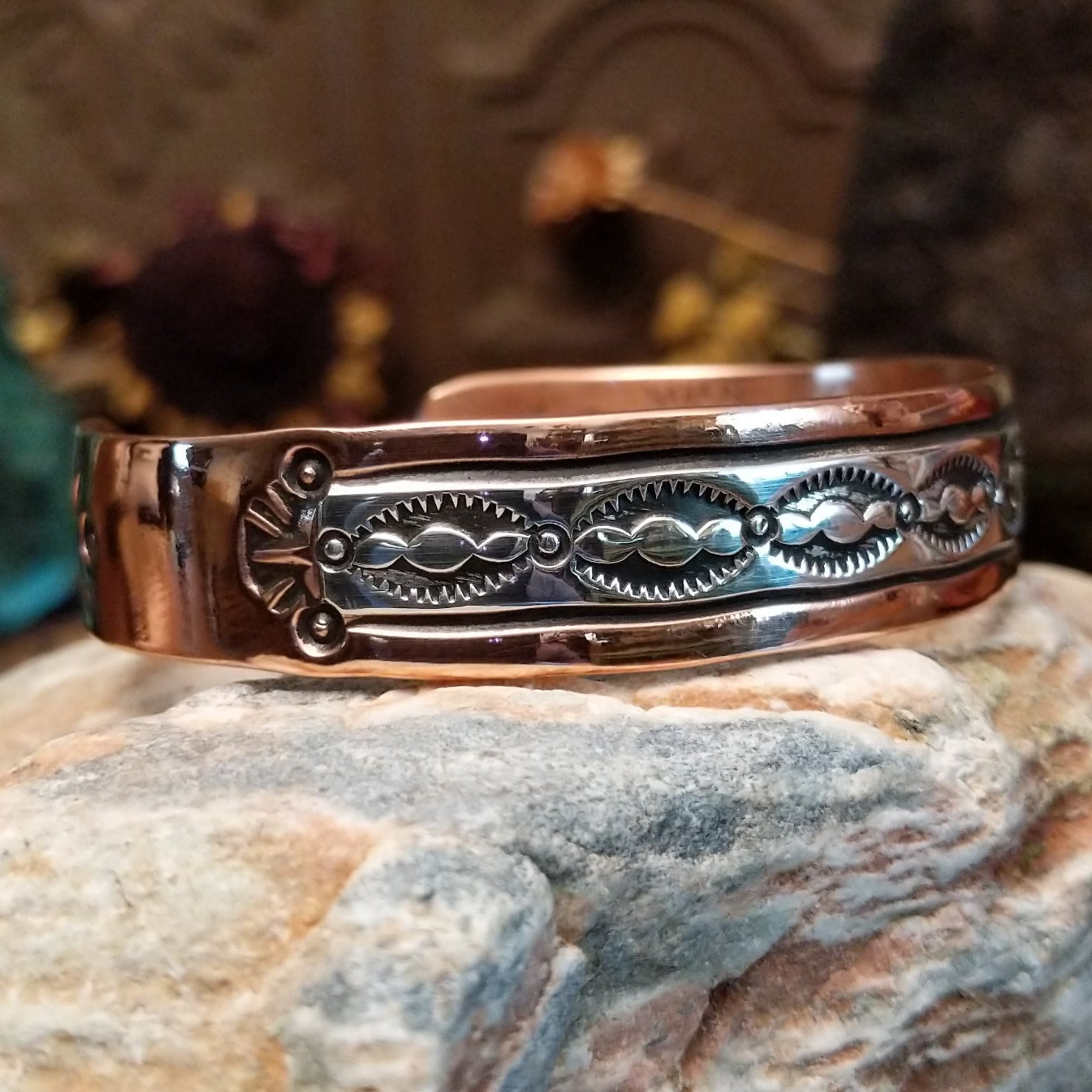 Handcrafted copper and sterling silver cuff bracelet by Navajo artisan Robert Little featuring wavy stamped detailing in a traditional Southwestern design. Side view.