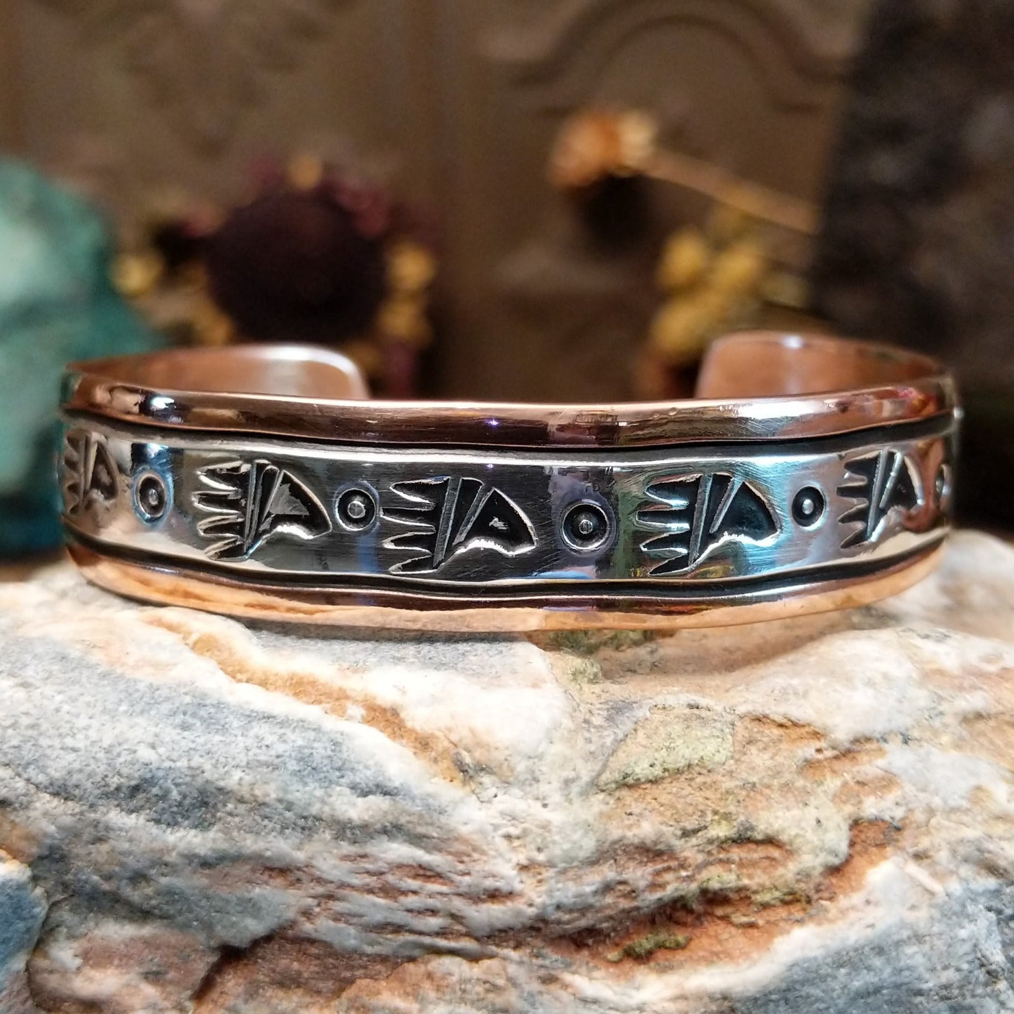 Handcrafted copper and sterling silver cuff bracelet by Navajo artisan Robert Little featuring bear paw stamped detailing in a traditional Southwestern design.
