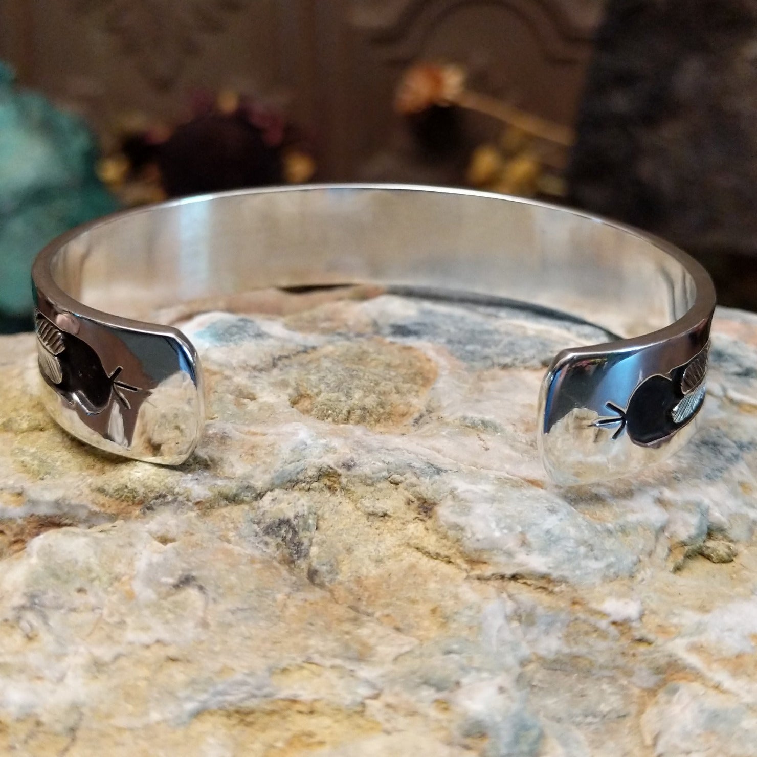 Handcrafted sterling silver cuff bracelet by Navajo artist Gilbert Begay featuring an engraved landscape storyteller design with traditional Southwestern details. Underside view.