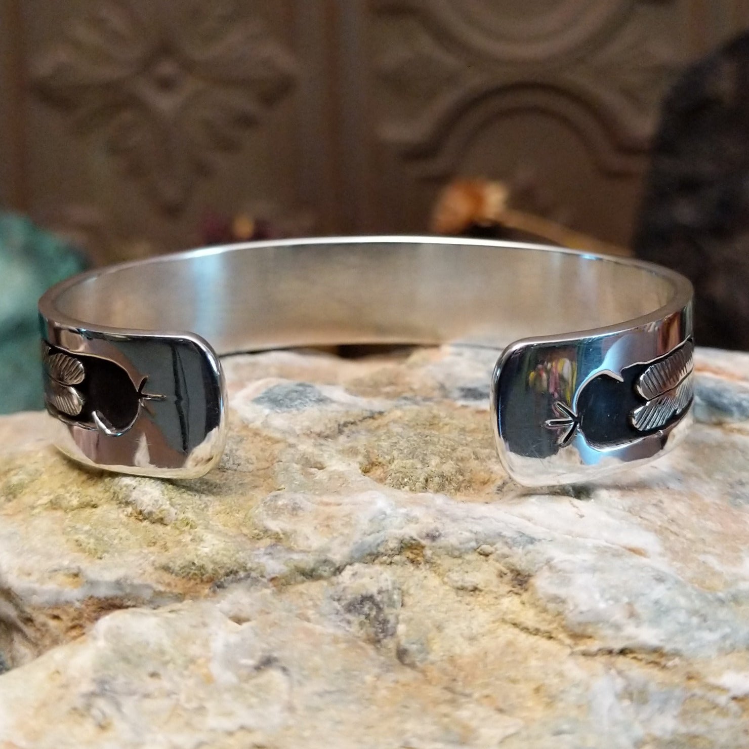 Handcrafted sterling silver cuff bracelet by Navajo artist Gilbert Begay featuring an engraved friendship dance storyteller scene in a traditional Southwestern design. Underside view.