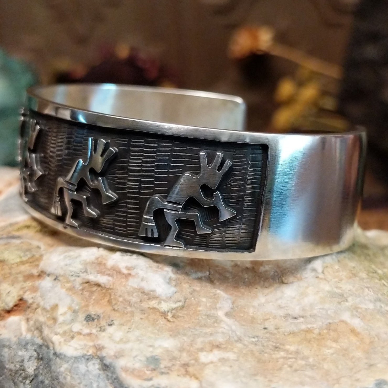 Handcrafted sterling silver cuff bracelet by Hopi artist Melinda Lucas featuring a carved Kokopelli design in a traditional Southwestern style. Side view.