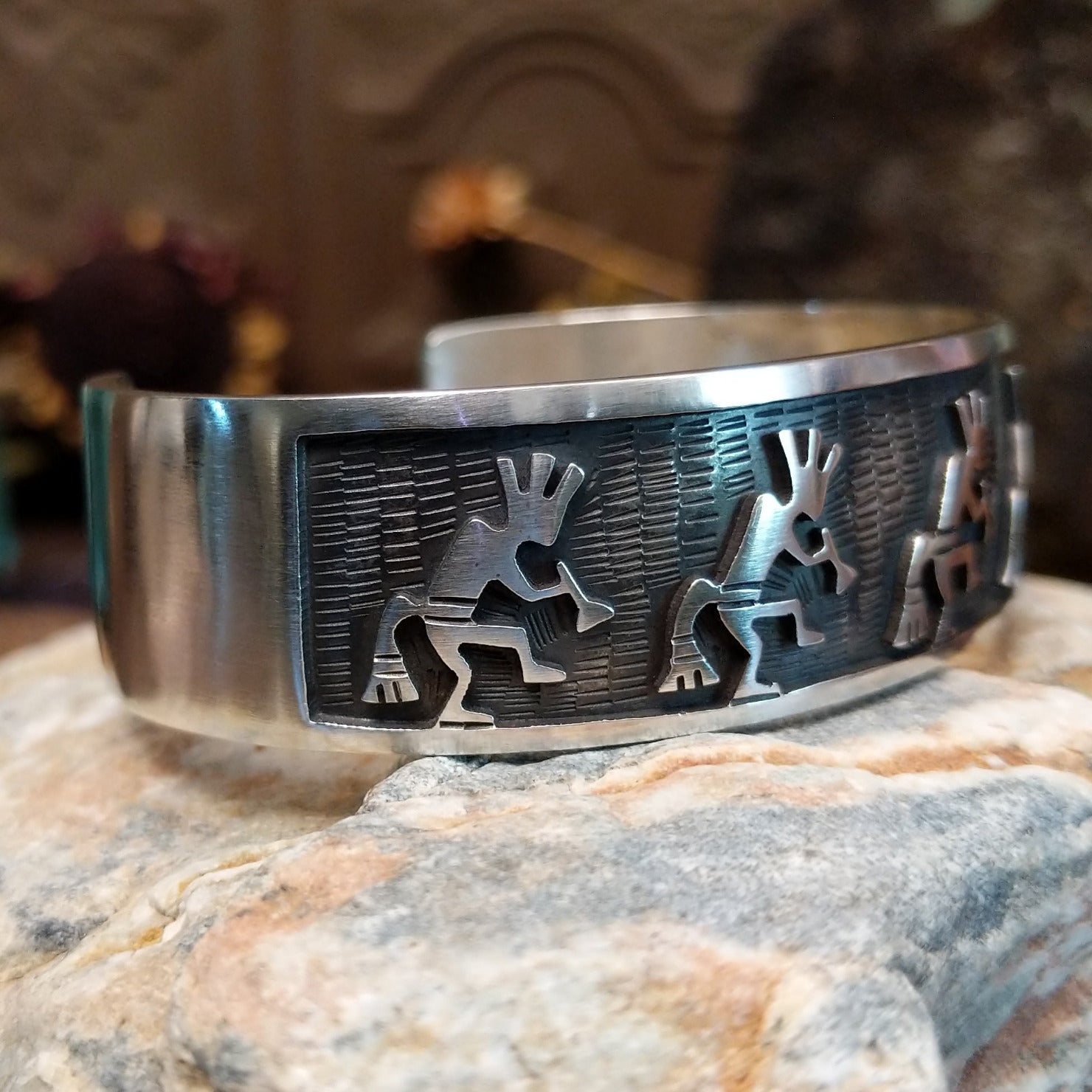 Handcrafted sterling silver cuff bracelet by Hopi artist Melinda Lucas featuring a carved Kokopelli design in a traditional Southwestern style. Side view.