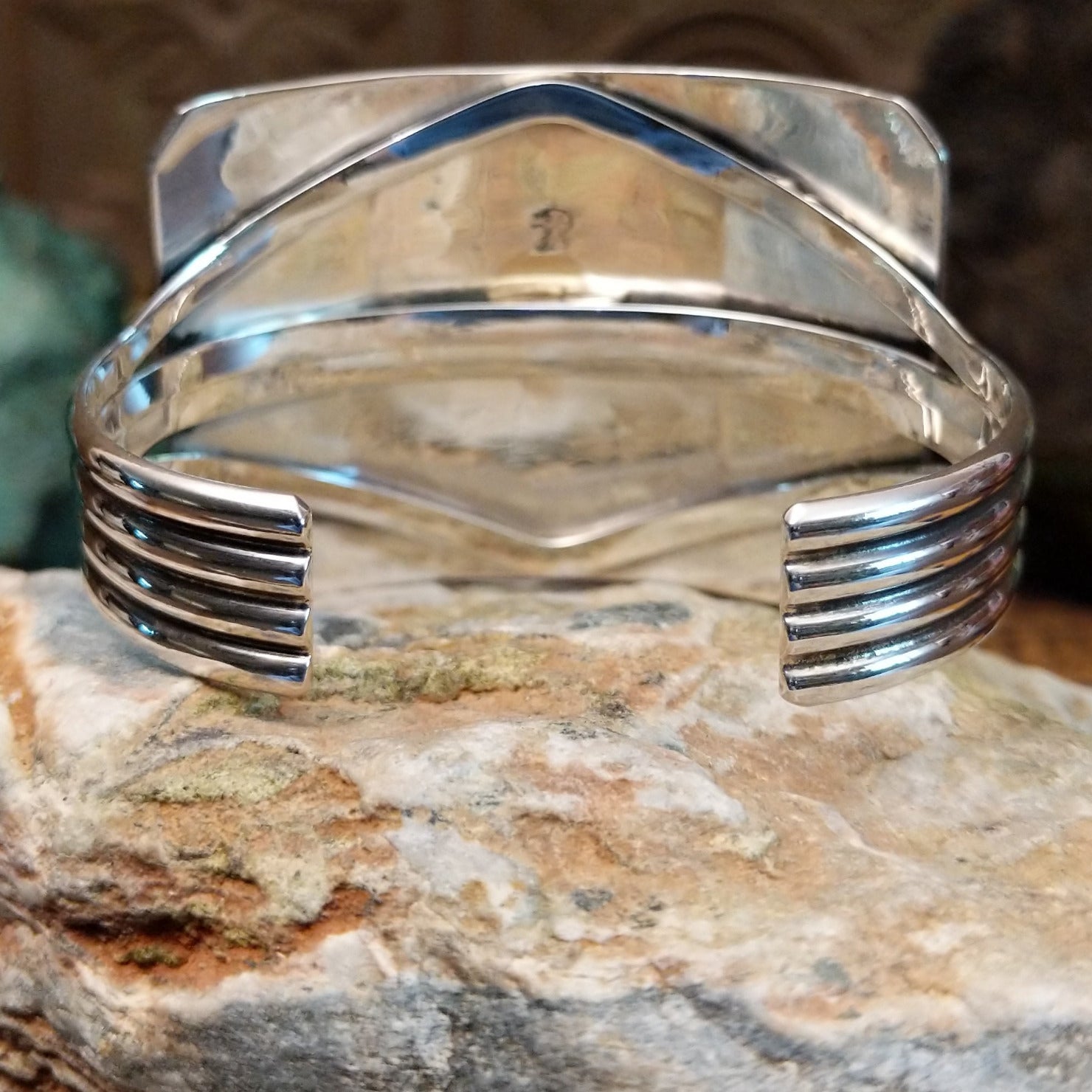 Handcrafted Navajo sterling silver cuff bracelet featuring a detailed Kokopelli design in a traditional Southwestern Native American style. Underside view.