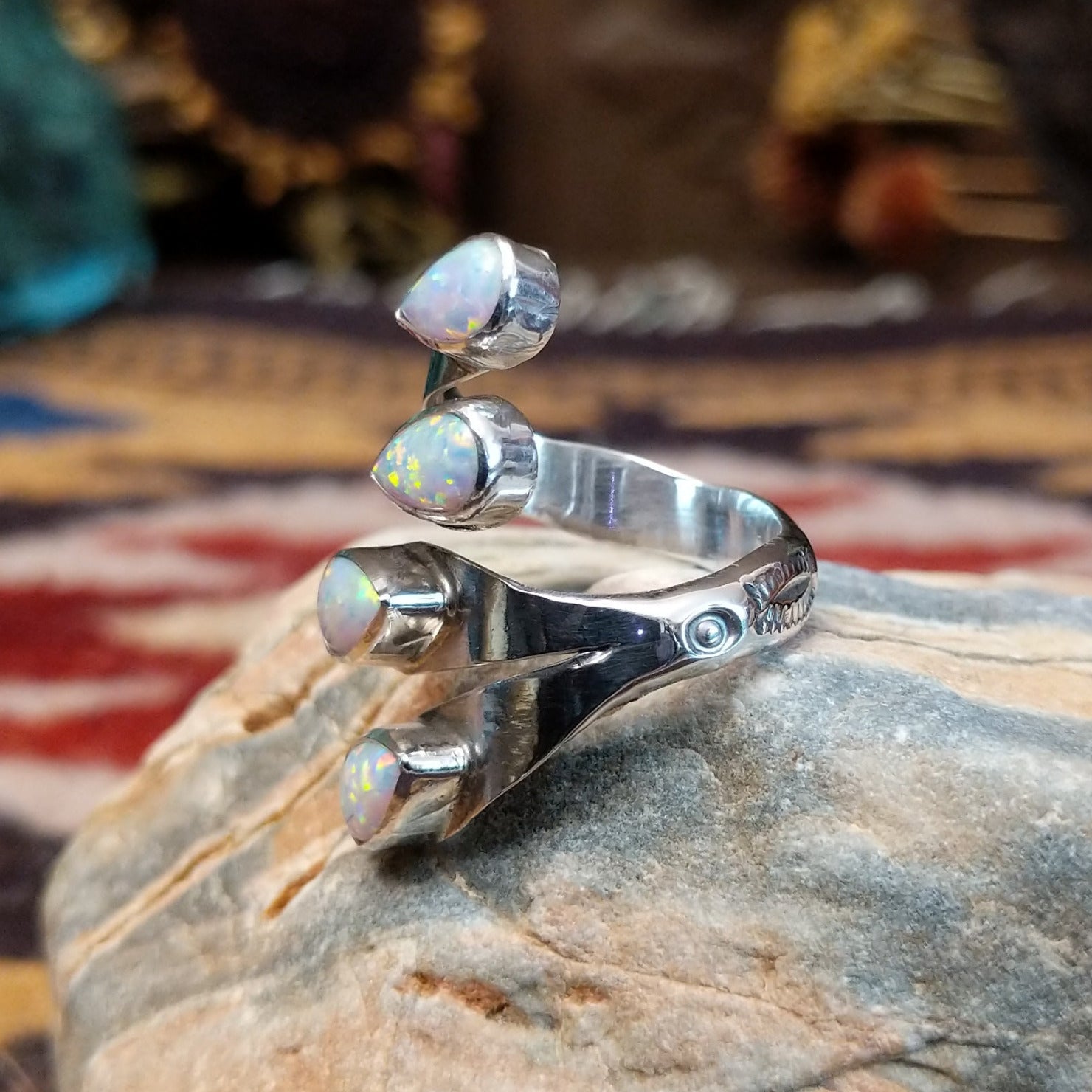 Handcrafted Navajo sterling silver teardrop ring featuring a white manmade opal with iridescent color play in a traditional Southwestern design. Side view.