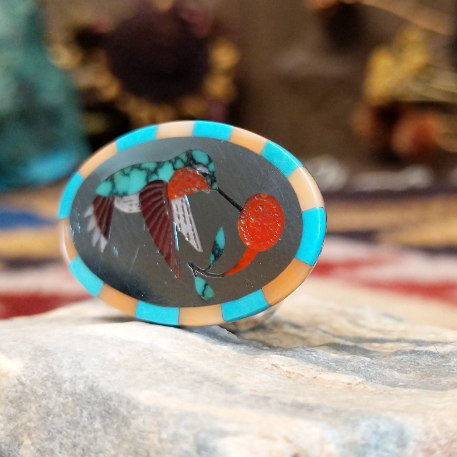 Handcrafted sterling silver hummingbird ring by Albert and Dolly Banteah featuring colorful multistone inlay in a traditional Zuni Southwestern design. Side view.