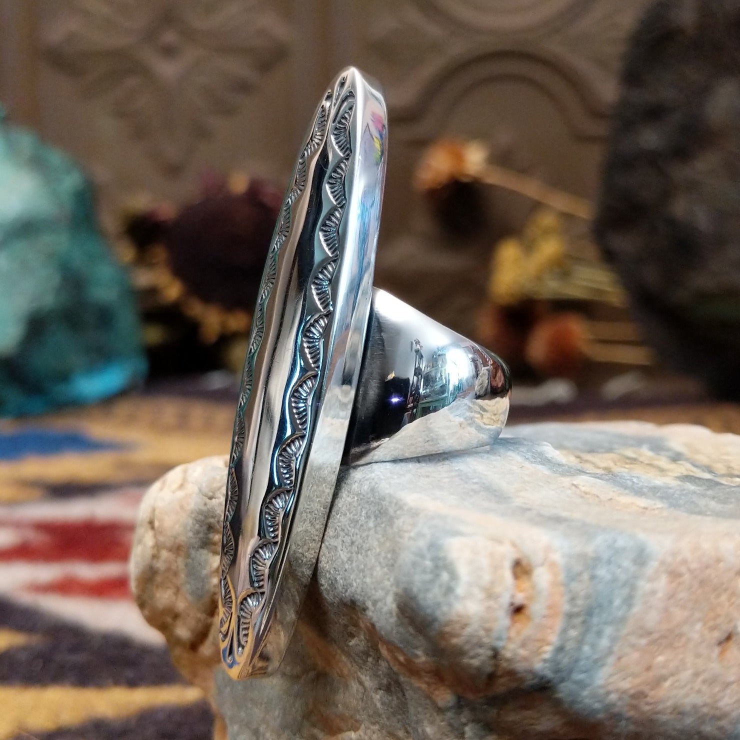 Handcrafted sterling silver navette ring by Ryan Sanchez featuring traditional stamped detailing in a Southwestern Native American design. Side view.