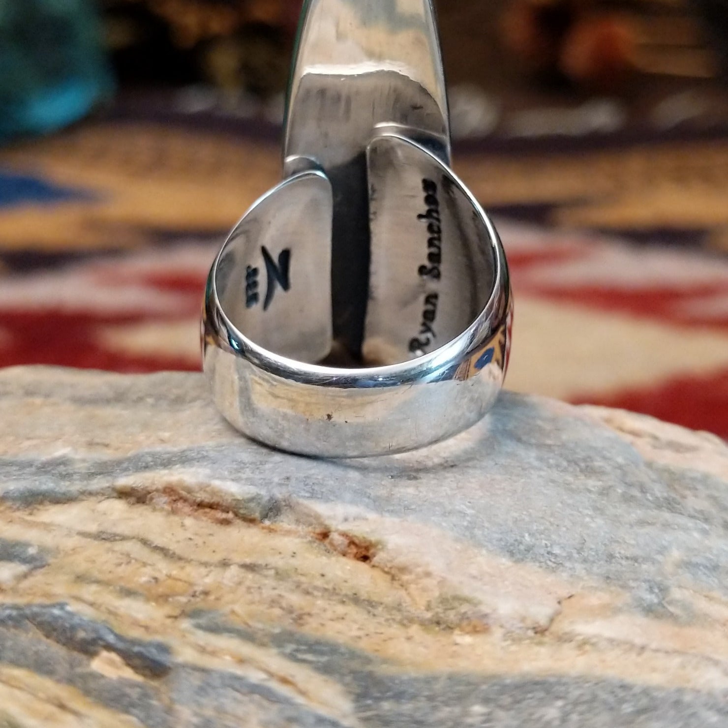 Handcrafted sterling silver navette ring by Ryan Sanchez featuring traditional stamped detailing in a Southwestern Native American design. Underside view.