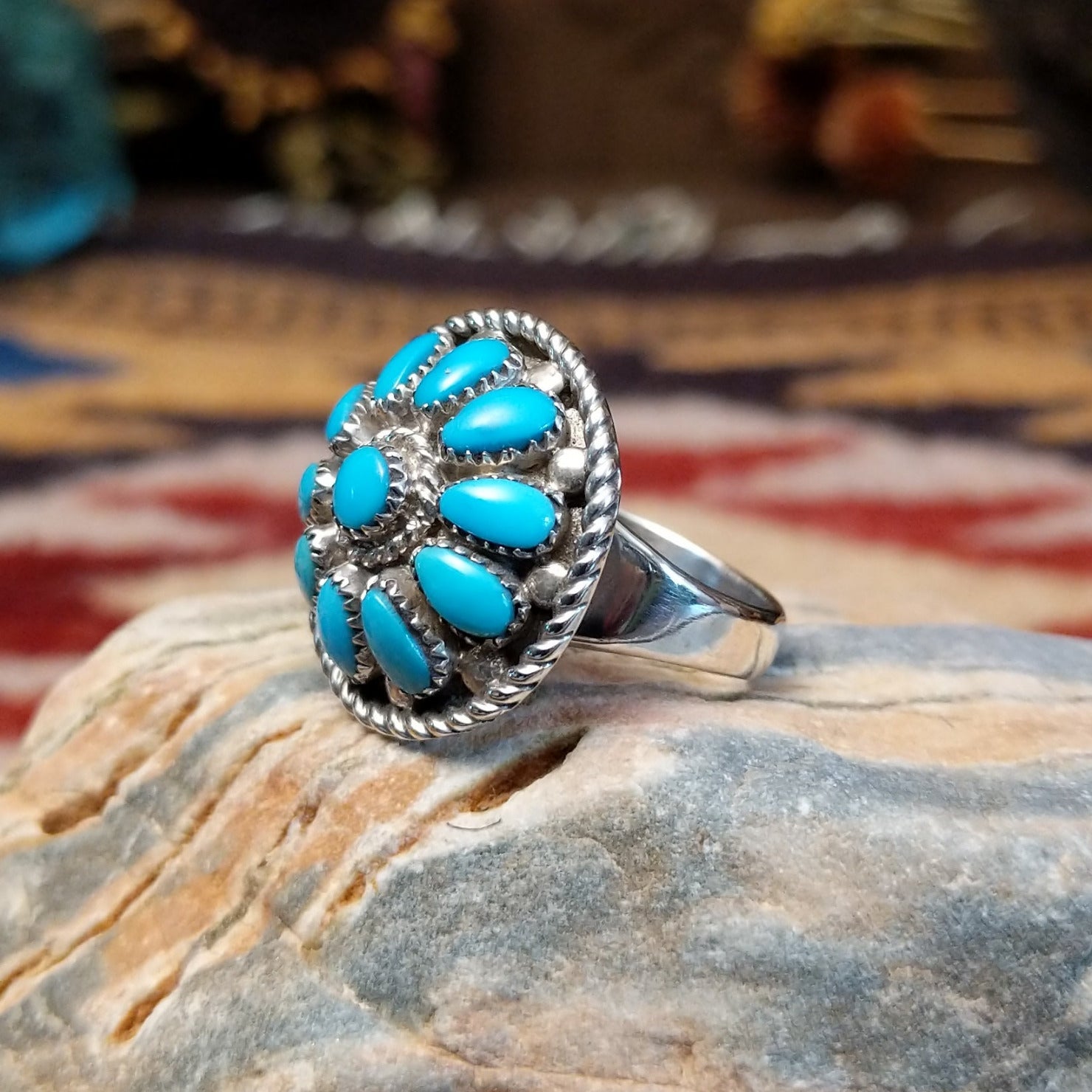 Handcrafted Navajo sterling silver ring by Lucy Jake featuring a turquoise stone with floral inspired traditional Southwestern design. Side view.