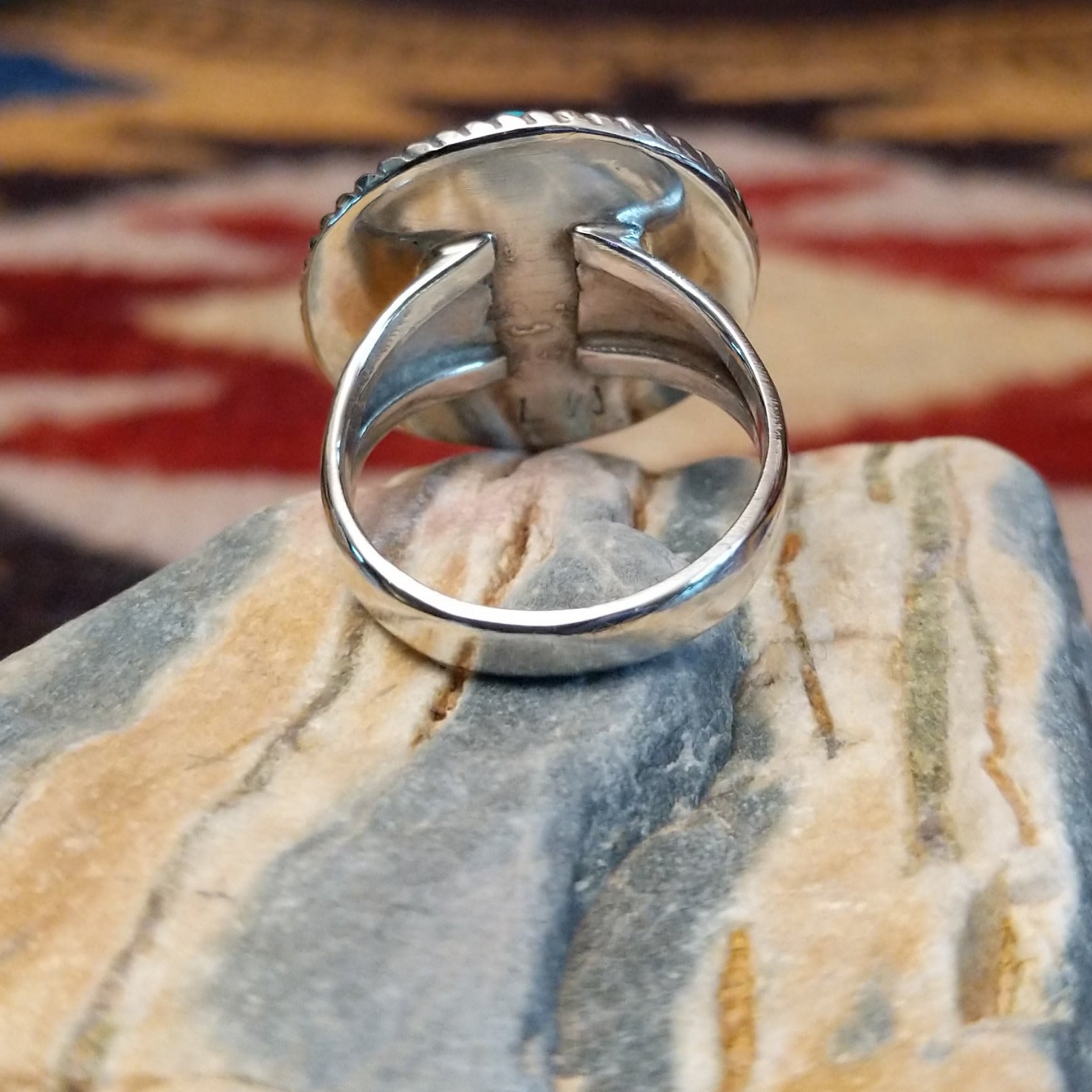 Handcrafted Navajo sterling silver ring by Lucy Jake featuring a turquoise stone with floral inspired traditional Southwestern design. Underside view.