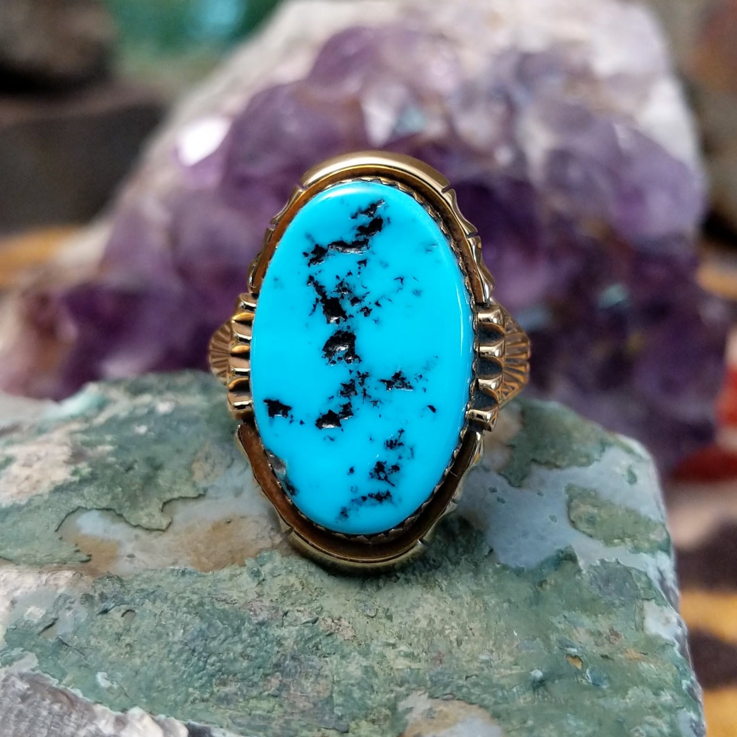 Oval turquoise ring set in a polished 14K yellow gold bezel by Delbert Gordon, featuring natural blue stone with visible matrix patterns and a smooth, minimal gold band design.