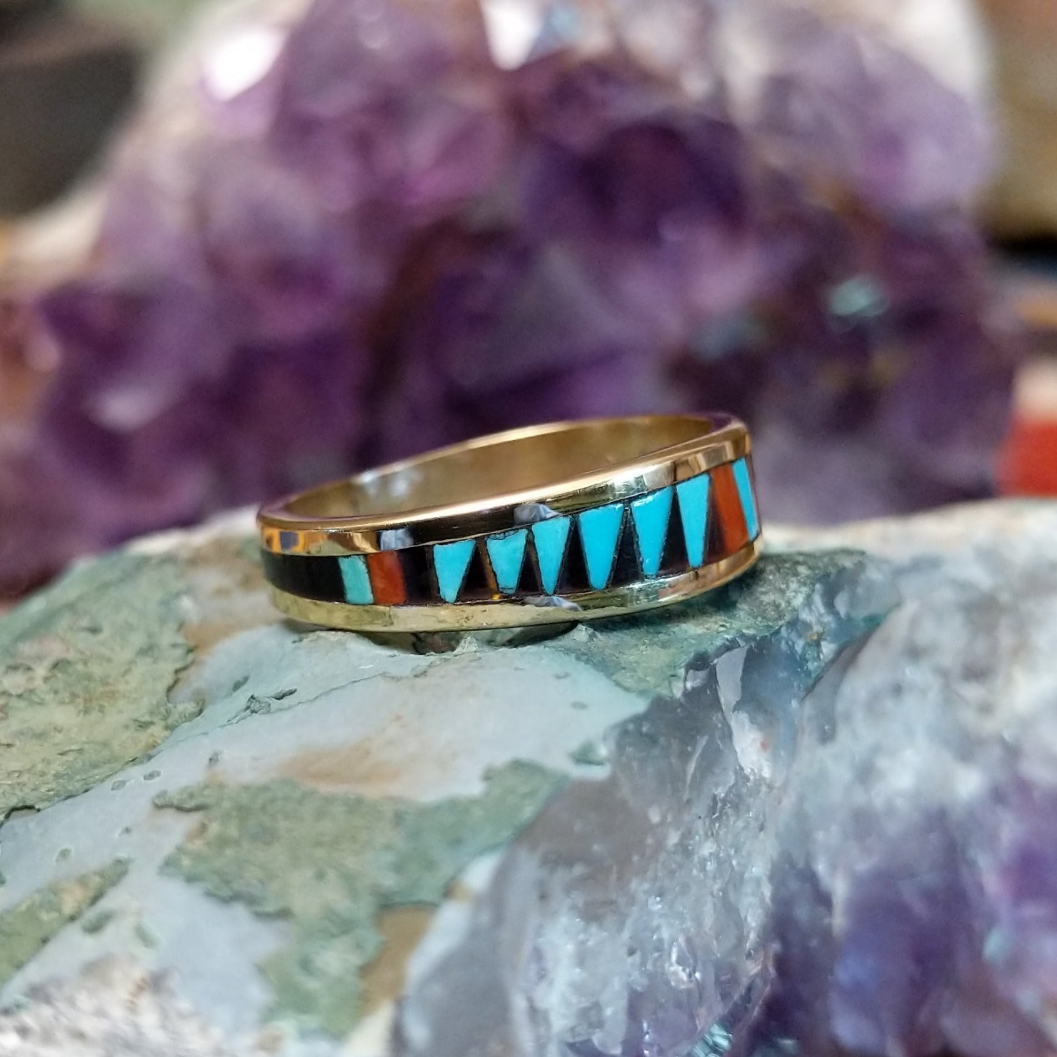 Zuni multistone inlay ring in 14K yellow gold by Charlotte Dishta, featuring precise geometric inlay work with multiple natural stones set into a polished gold band. Side view.