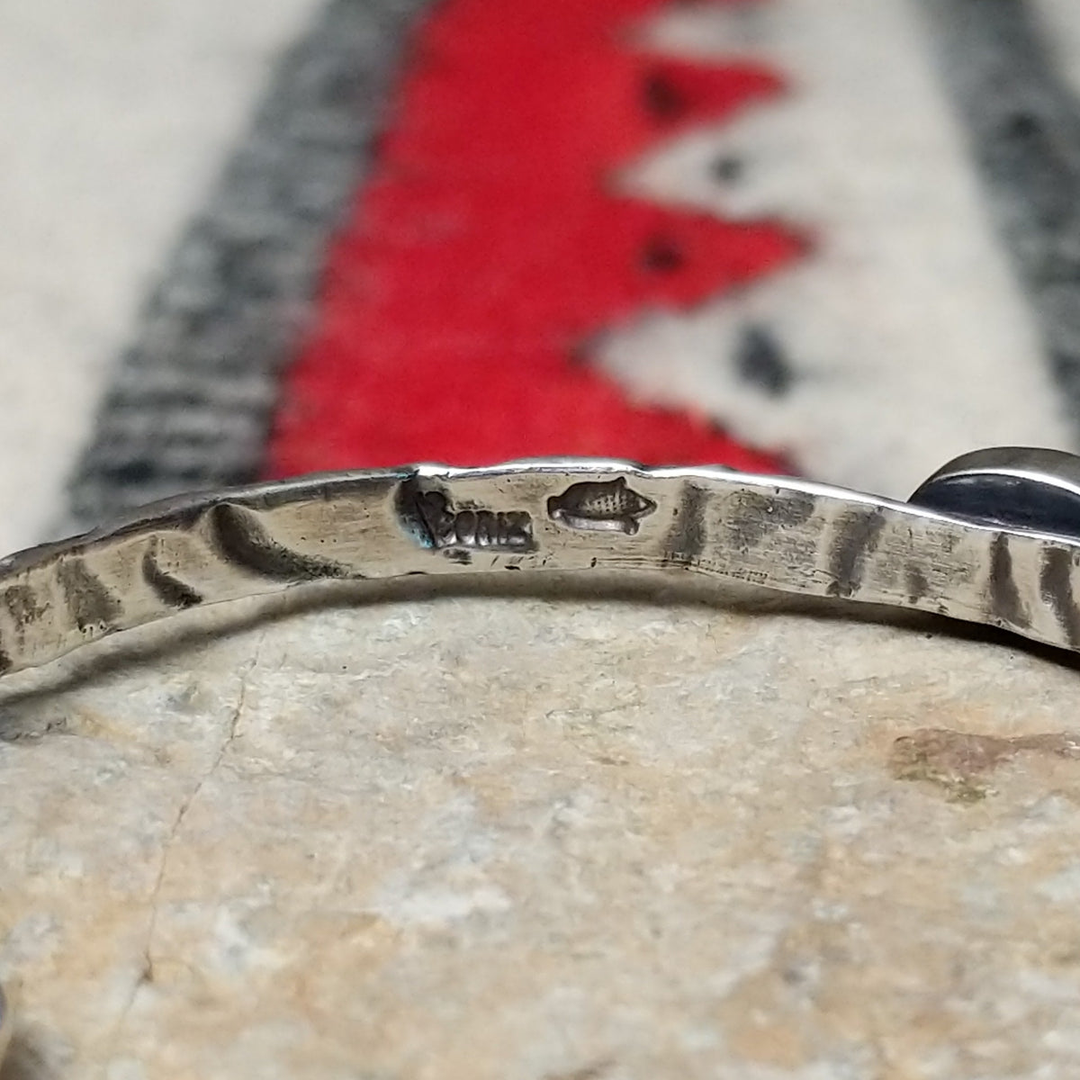 Slender silver cuff by Raymond Coriz featuring a pale green oval Palomino variscite stone centered on a textured, oxidized silver band; artisan and Sterling Silver stamp.