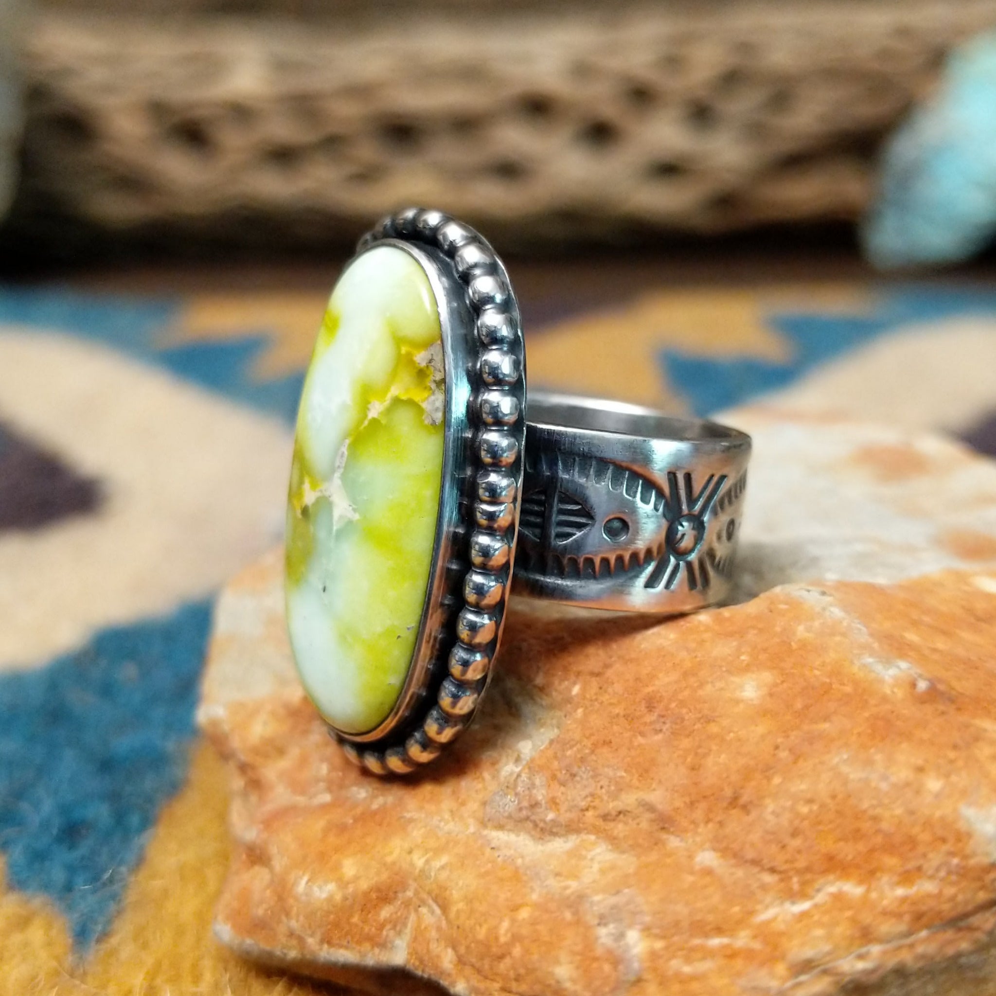 Handcrafted sterling silver Palomino Variscite oval ring by Raymond Coriz, featuring a natural green and white variscite gemstone with a beaded bezel; side view.