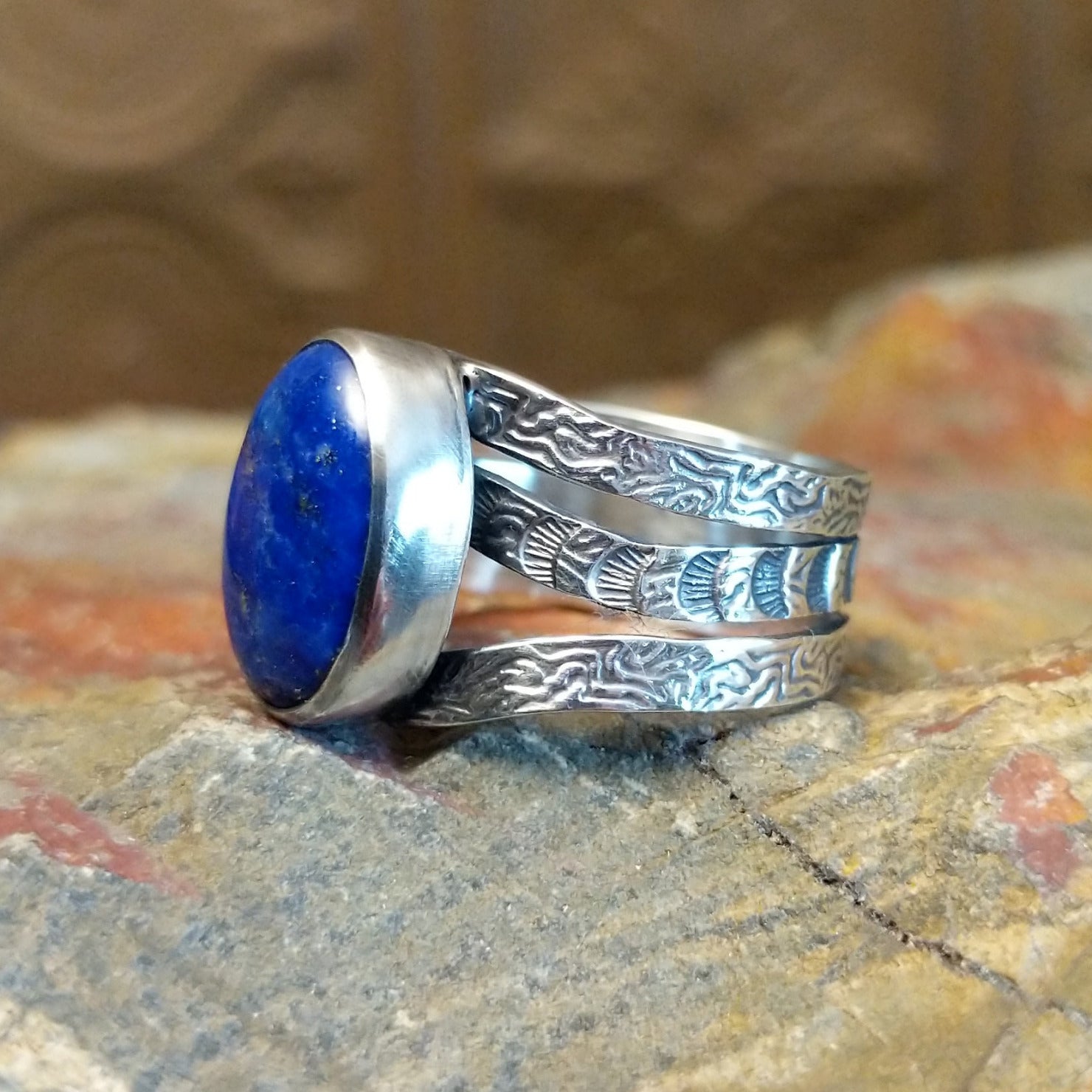 Sterling silver ring with lapis set in the bezel and patterned stamping on the band.
