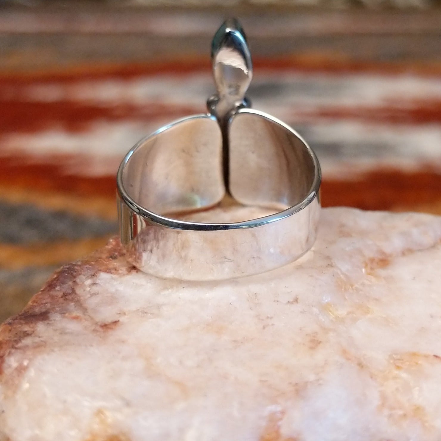 Sterling silver ring with trio bezels and pink coral set within.