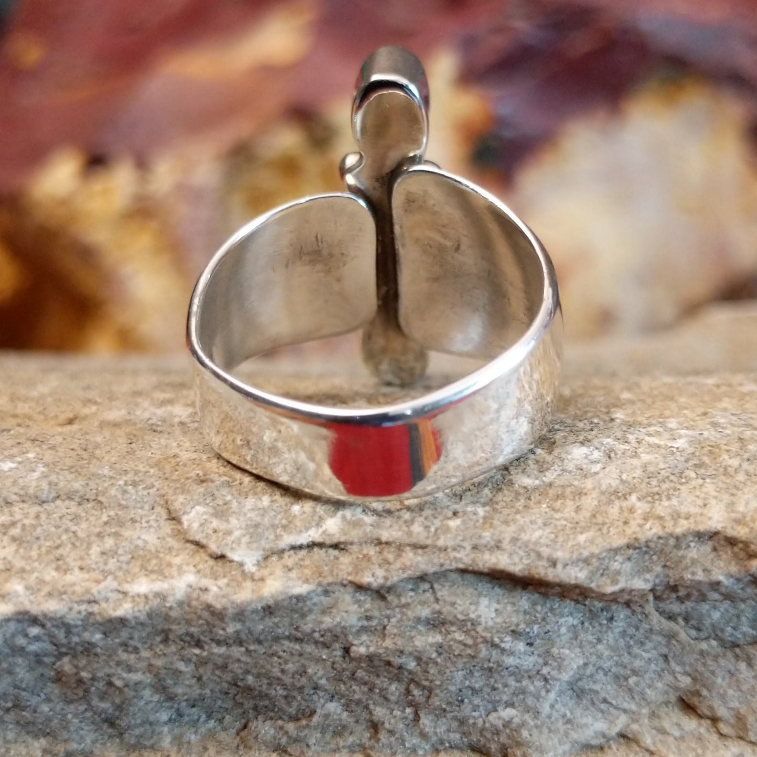 Tapered, polished silver band of the ring.