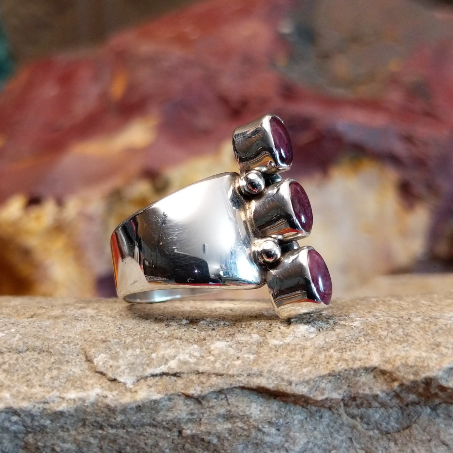 Three small purple spiny oyster shells set on the polished sterling silver band.